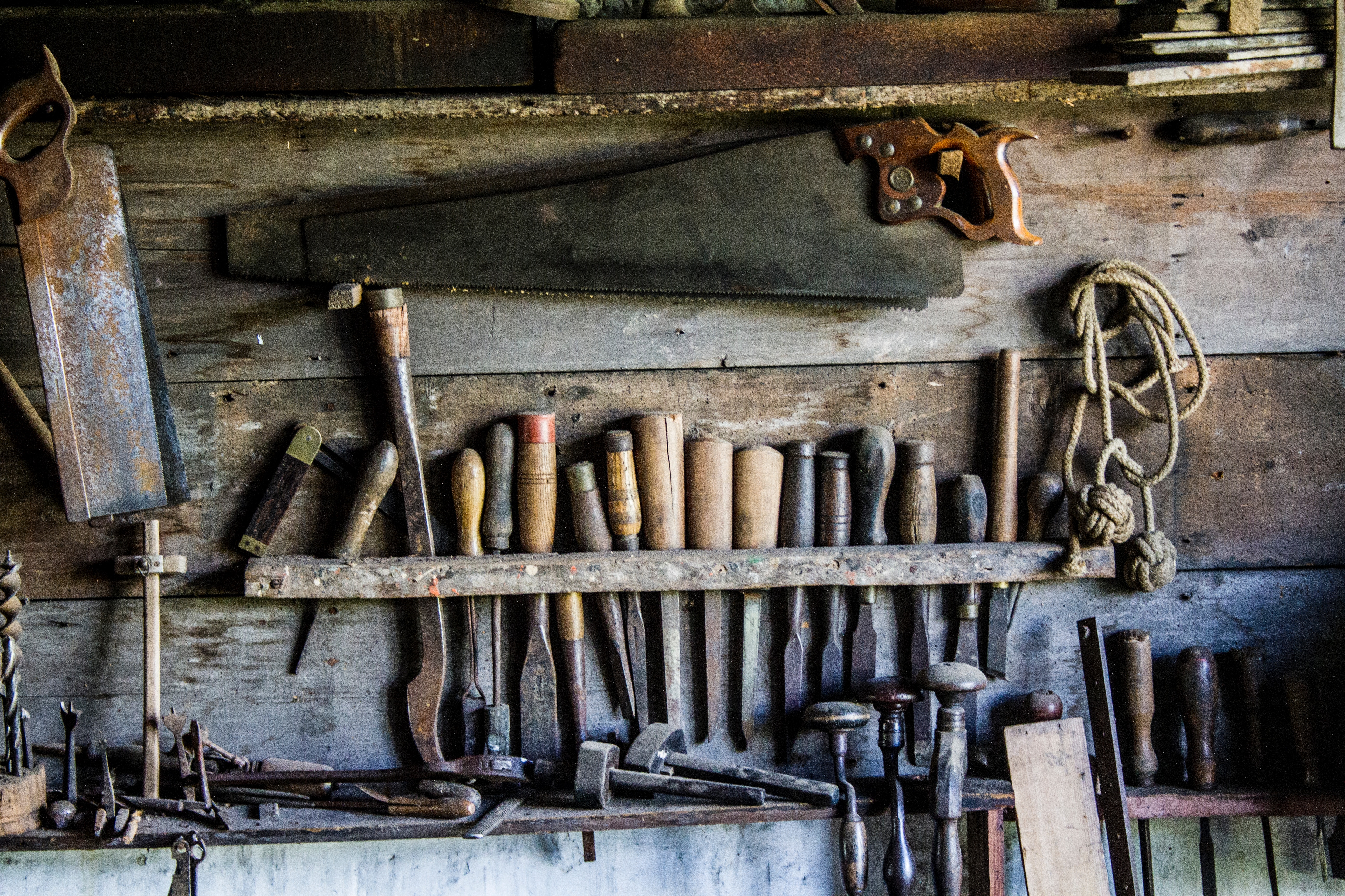 Rustic workshop with vintage woodworking tools and saws HD Wallpaper