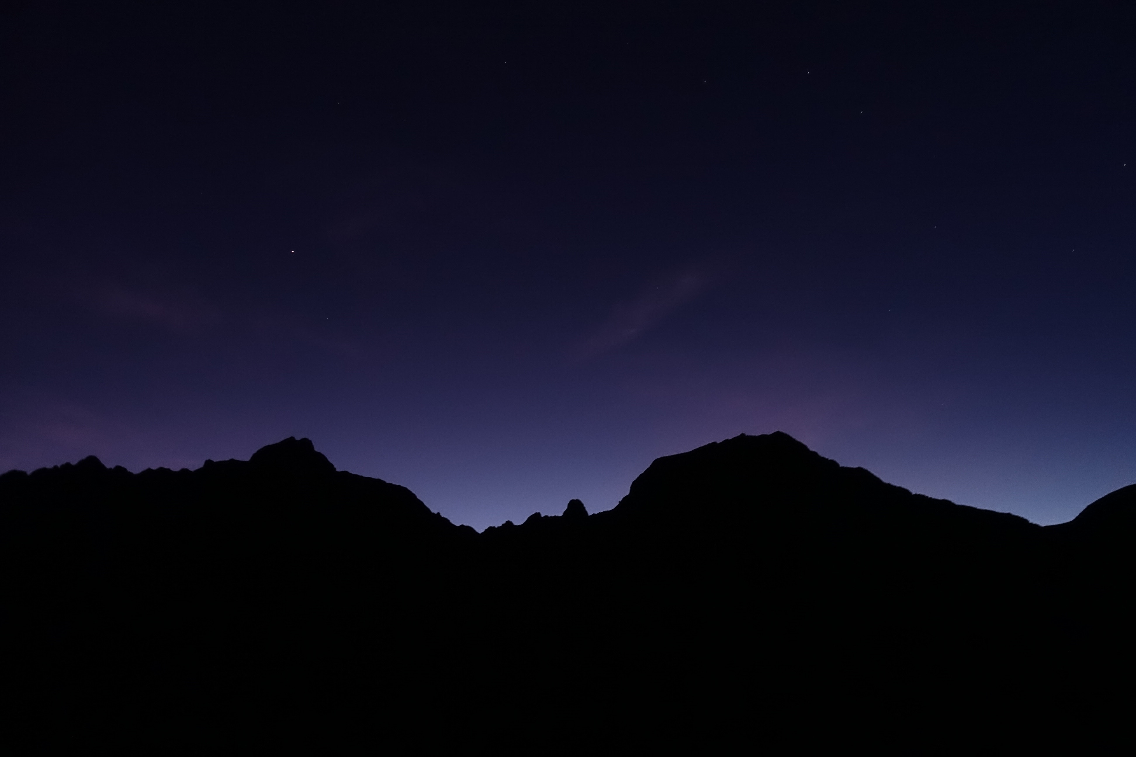 Silhouette of mountains against a starry night sky HD Wallpaper