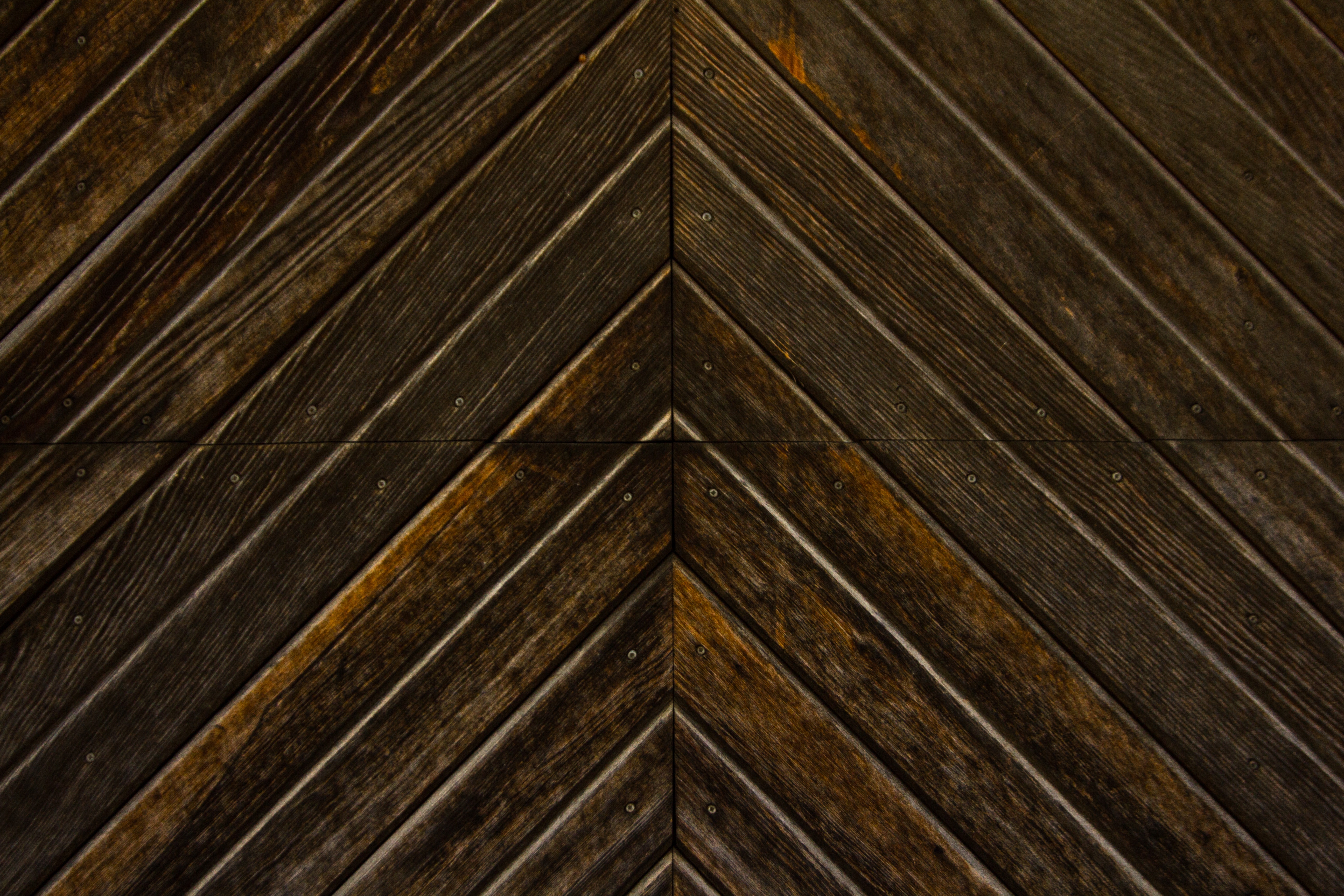 Dark wooden planks arranged in a chevron pattern HD Wallpaper
