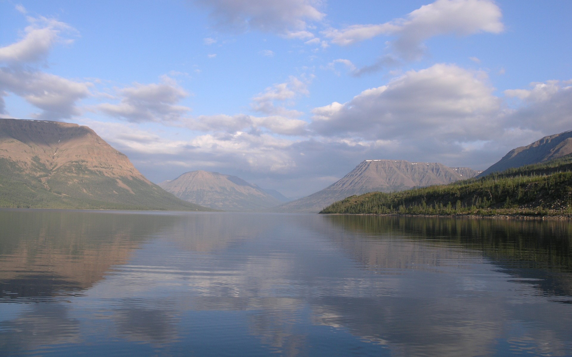 Calm lake reflecting mountains and sky HD Wallpaper