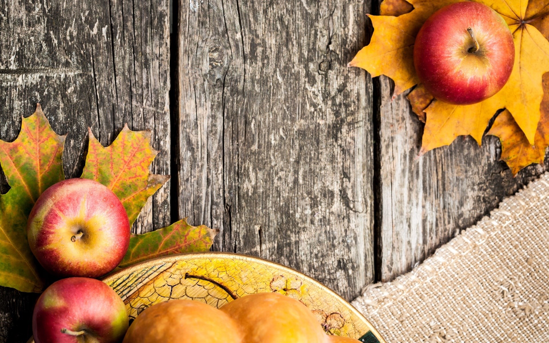 Apples and autumn leaves on a wooden table HD Wallpaper