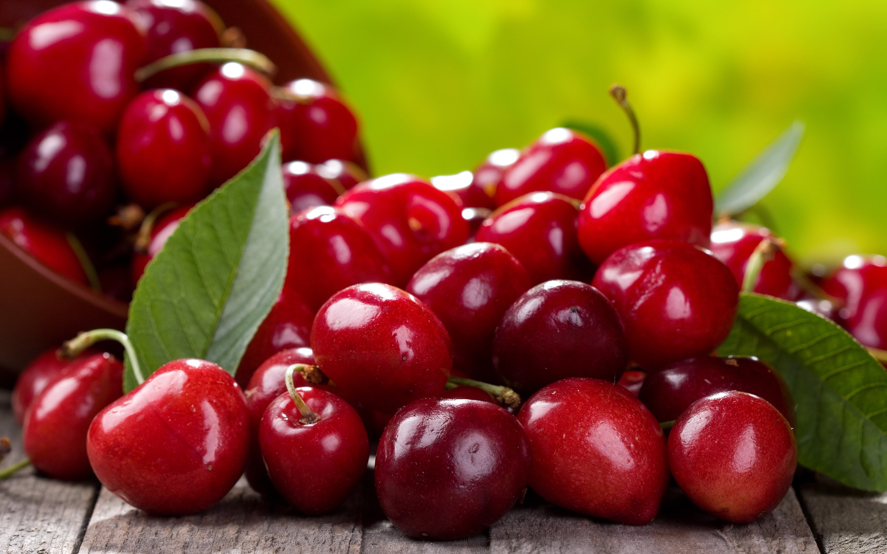 Cherries in a bowl on a wooden table HD Wallpaper