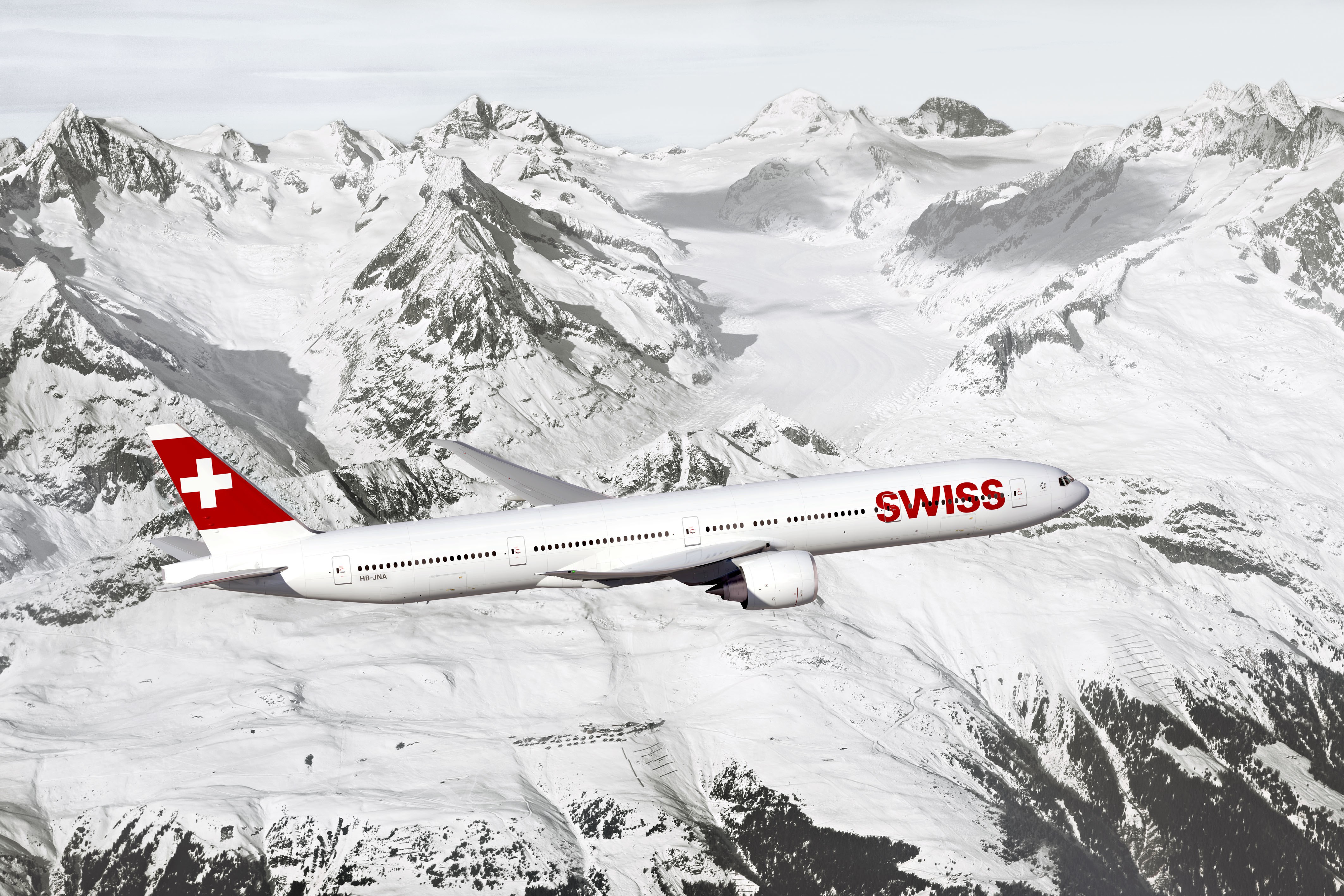 Swiss Boeing 777 flying over snowy mountains HD Wallpaper