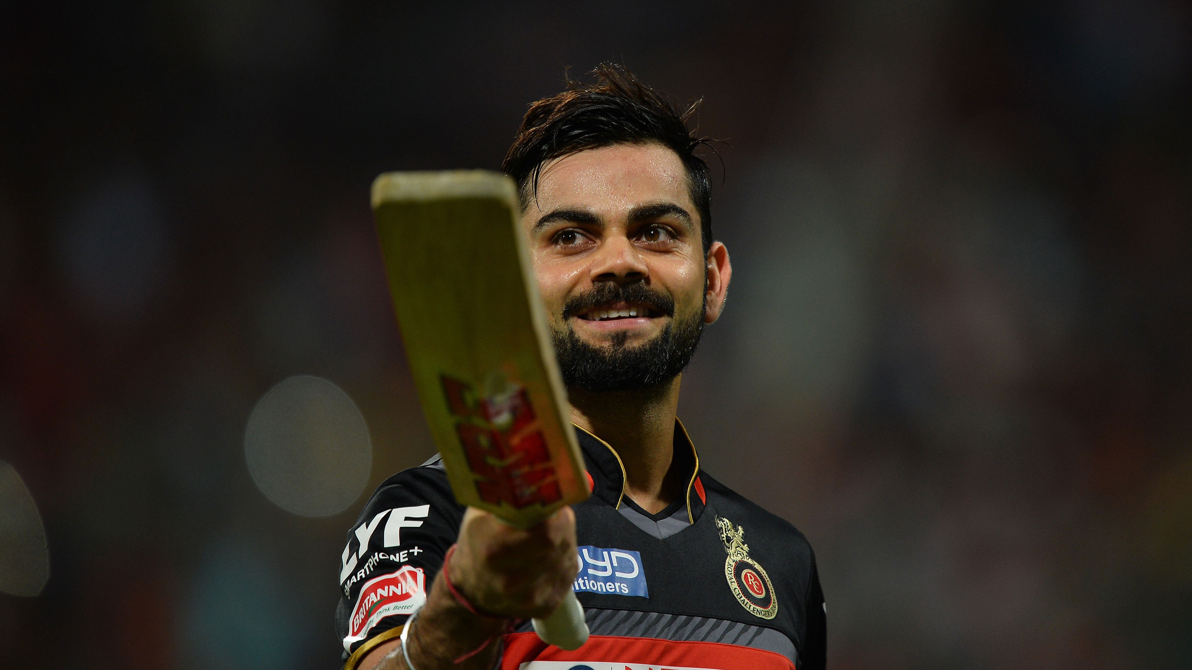Virat Kohli holding a cricket bat HD Wallpaper