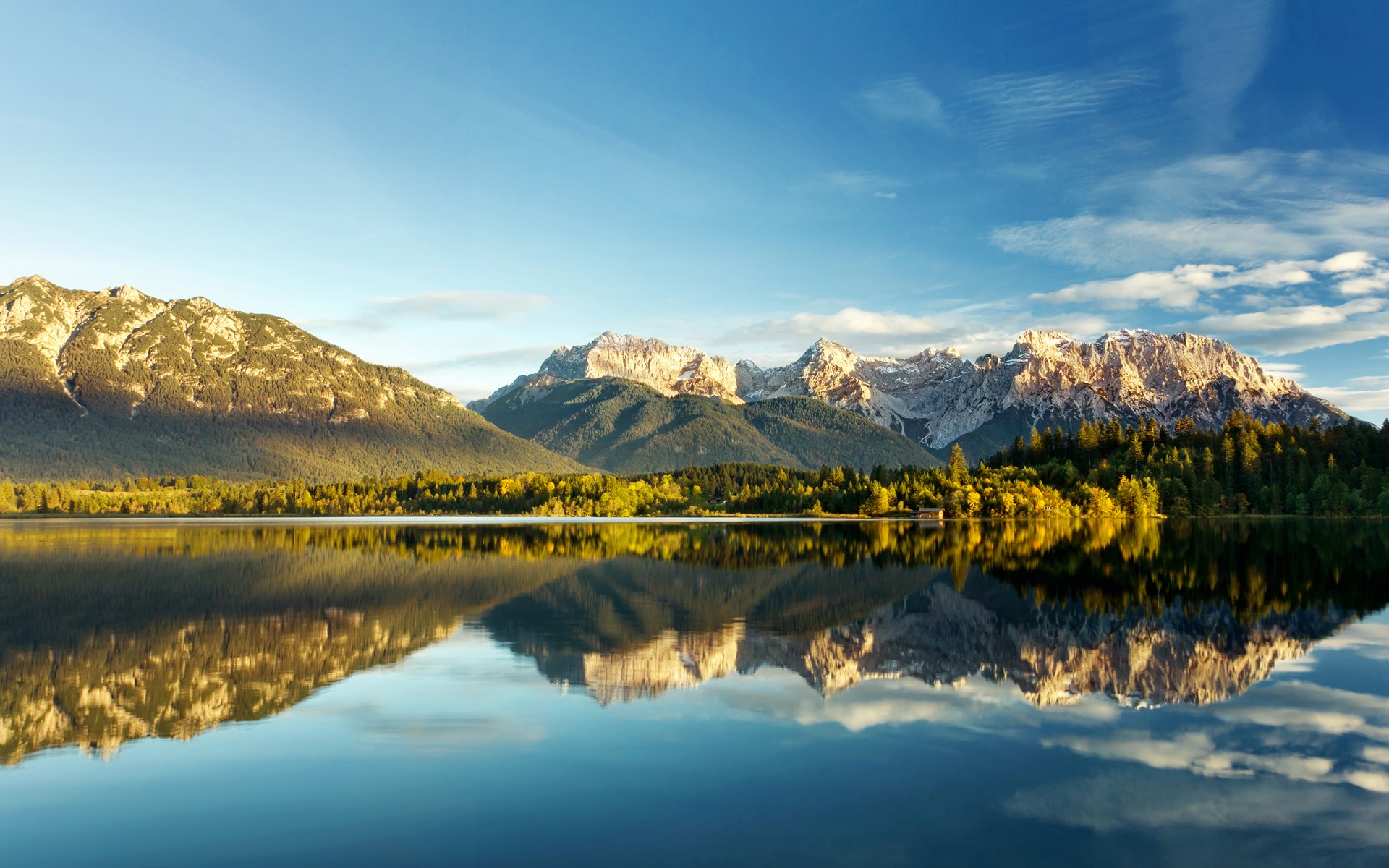 Mountain range reflected in a calm lake at sunrise HD Wallpaper