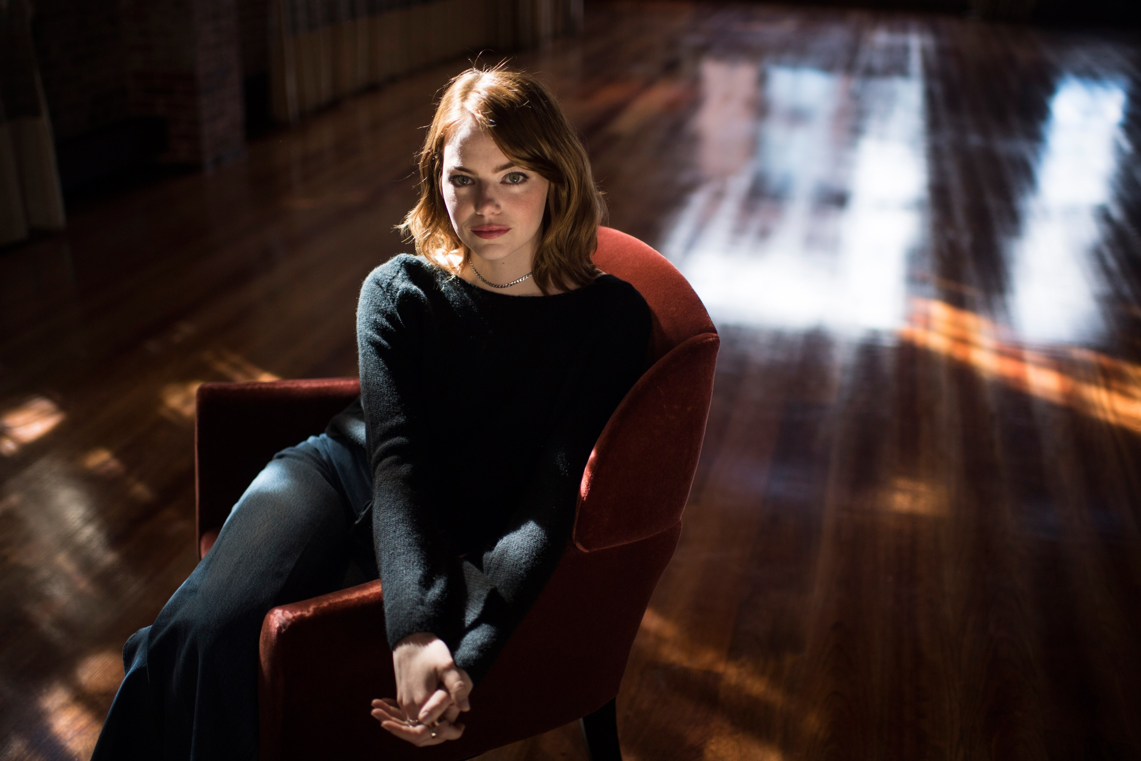 Emma Stone sitting in a chair HD Wallpaper