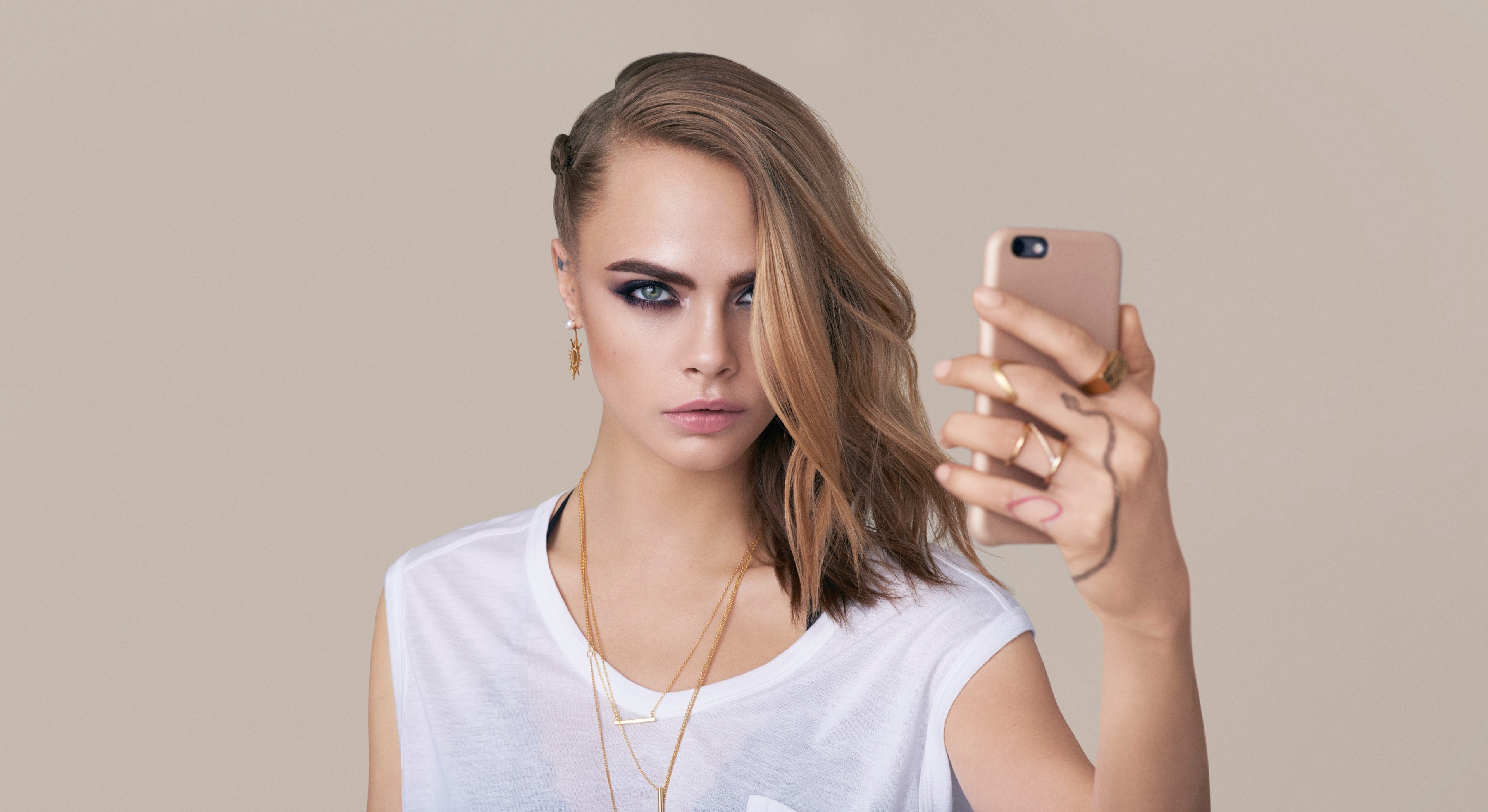 Cara Delevingne taking a selfie with a phone HD Wallpaper