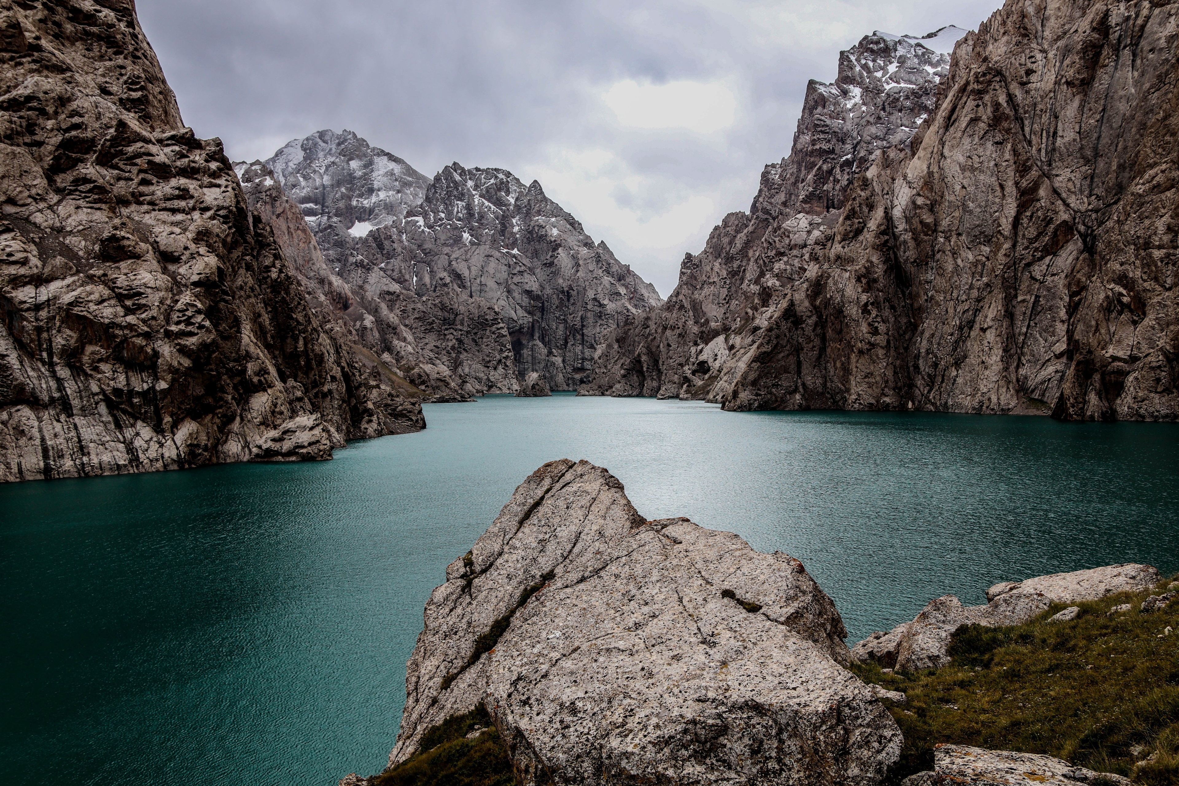 Turquoise lake surrounded by rocky mountains HD Wallpaper