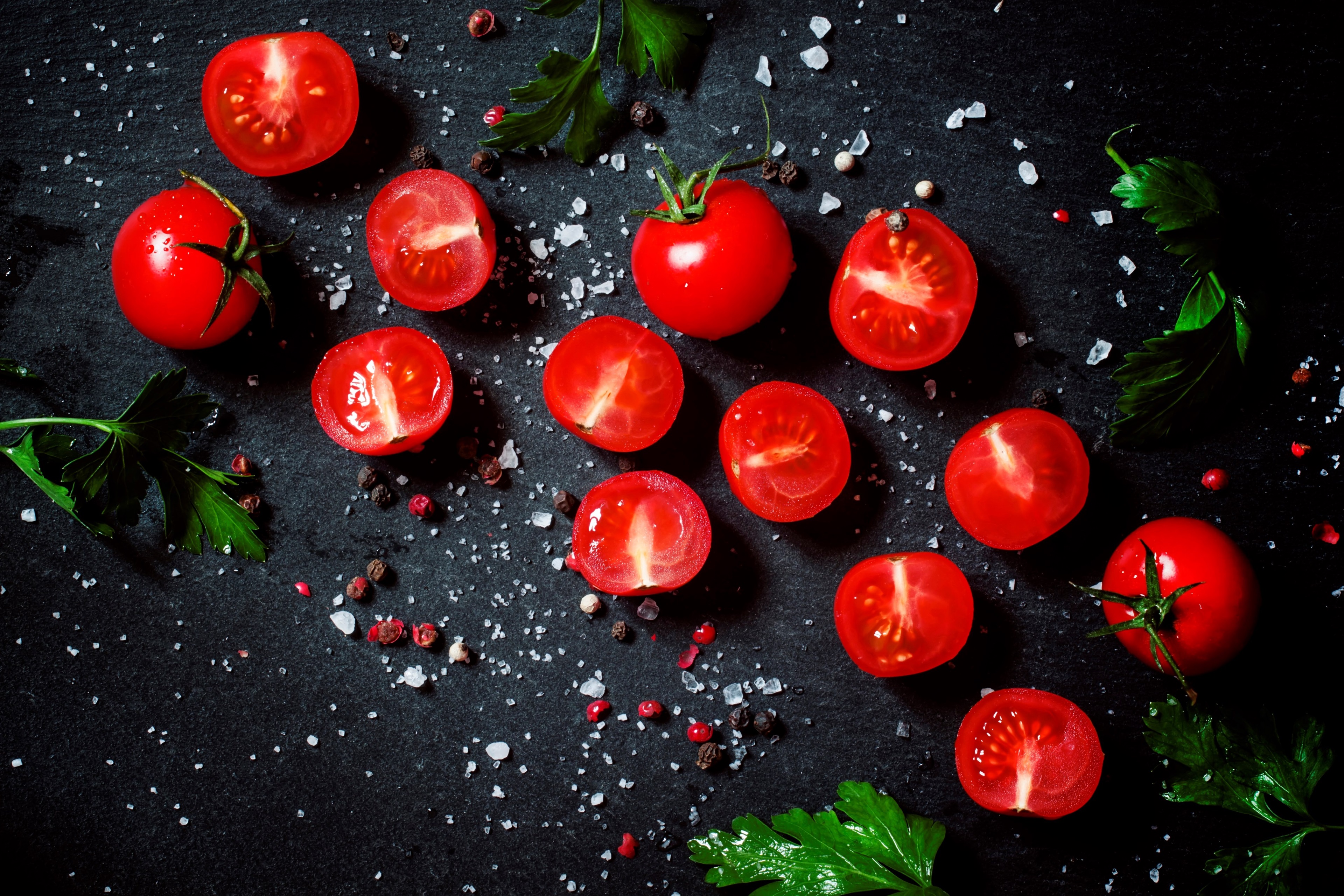 Tomatoes with salt and pepper on a dark surface HD Wallpaper