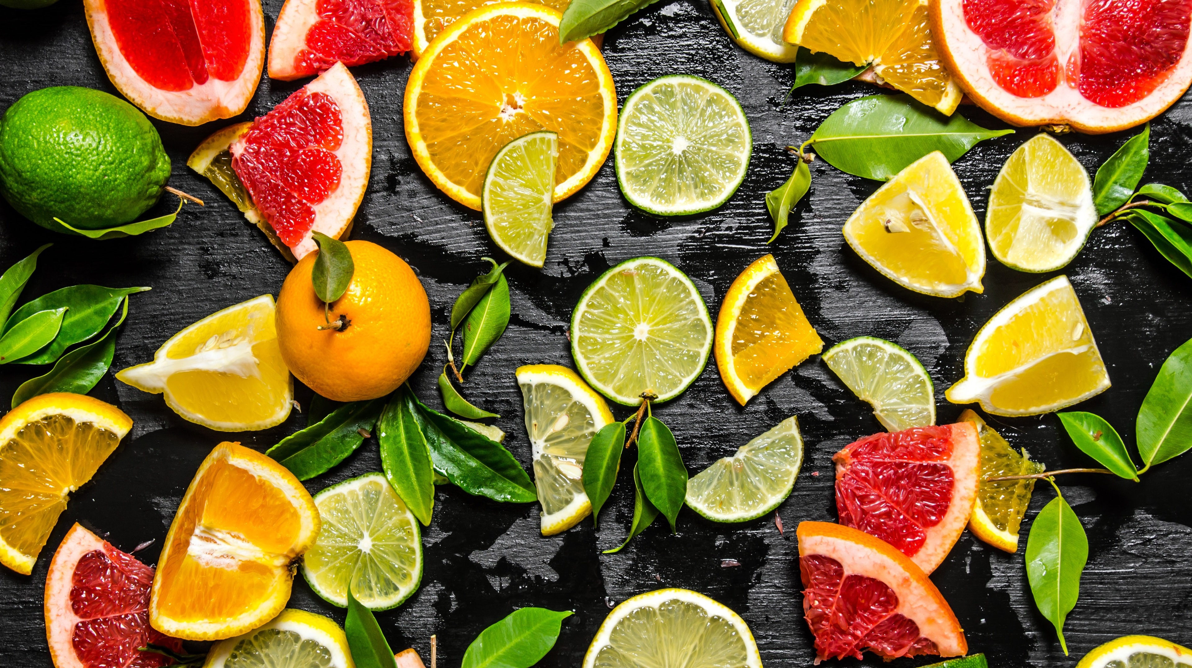 Assortment of Citrus Fruits on a Dark Surface HD Wallpaper