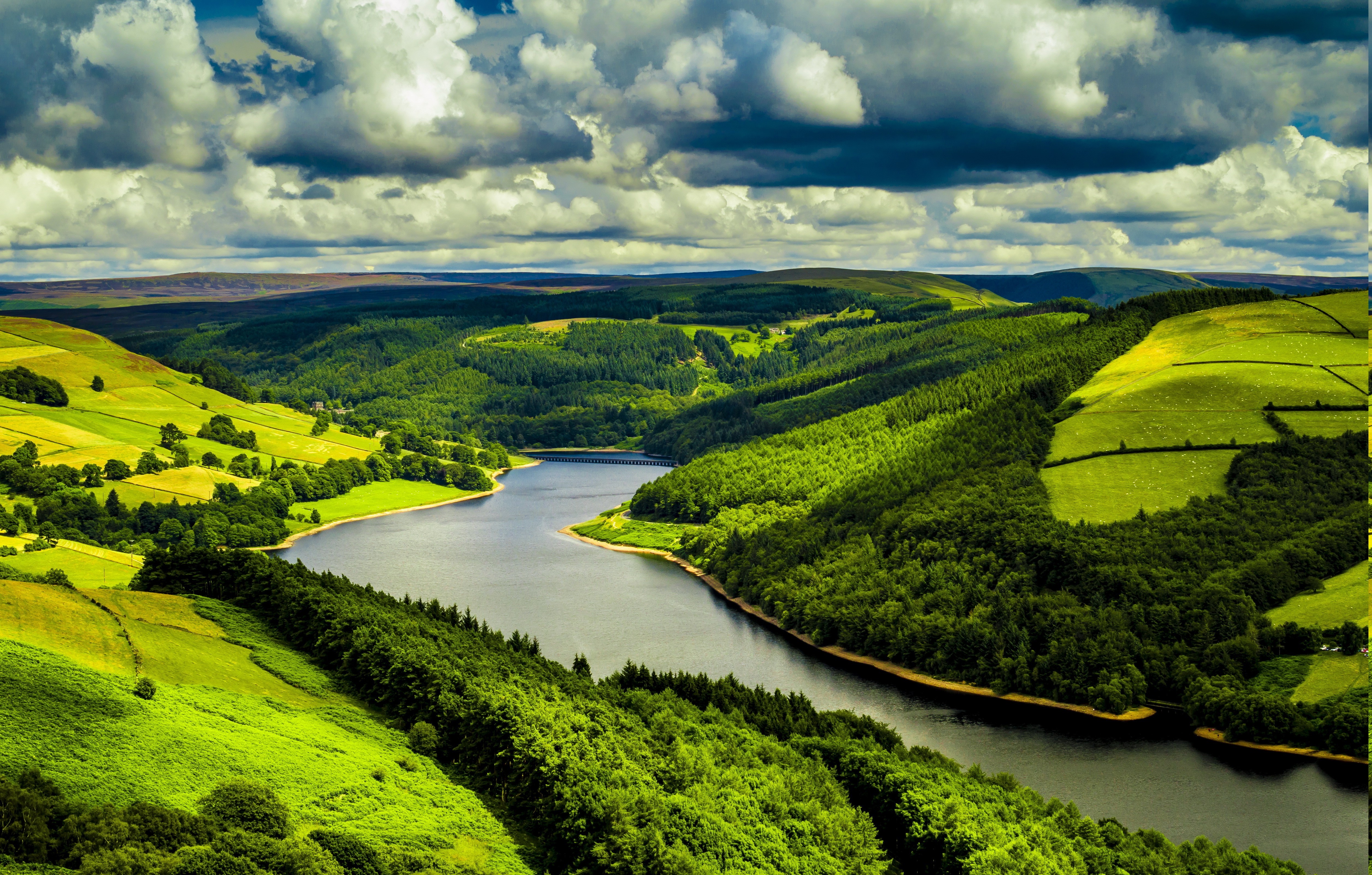 River valley with green hills and dramatic clouds HD Wallpaper