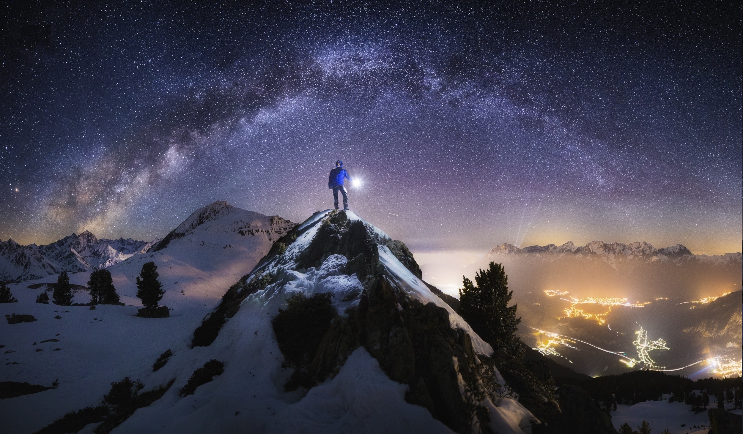 Man with flashlight on snowy mountain under Milky Way HD Wallpaper
