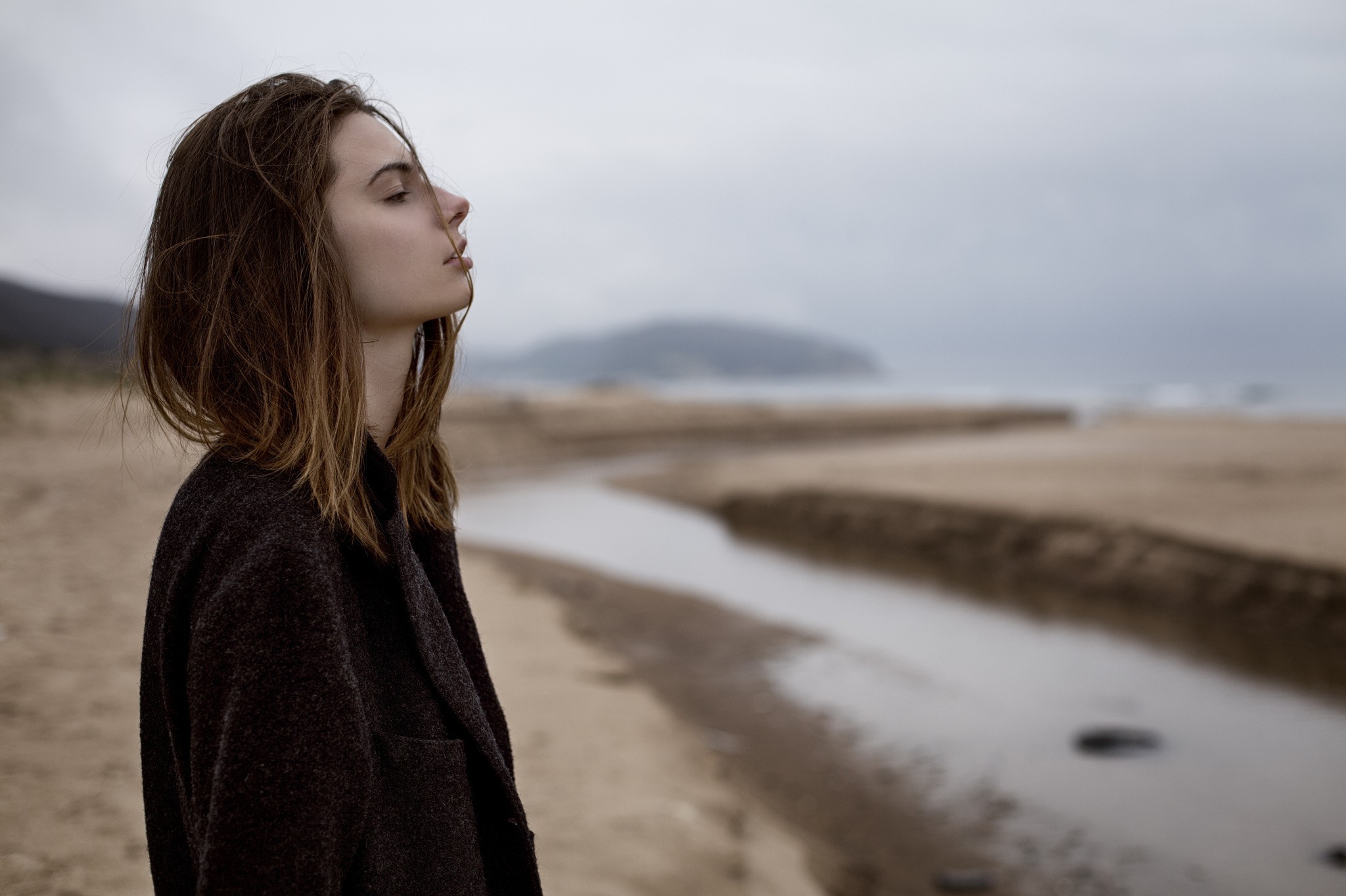 Woman in coat on a beach HD Wallpaper