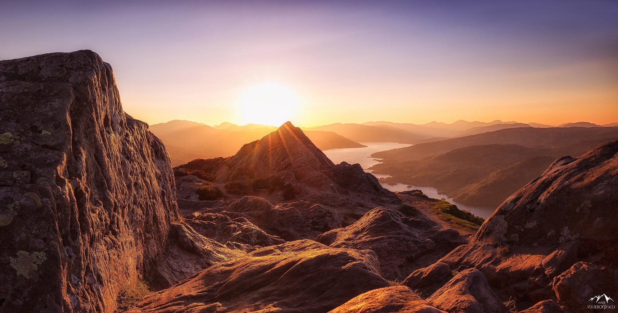 Sunrise over mountains and lake with rocky foreground HD Wallpaper