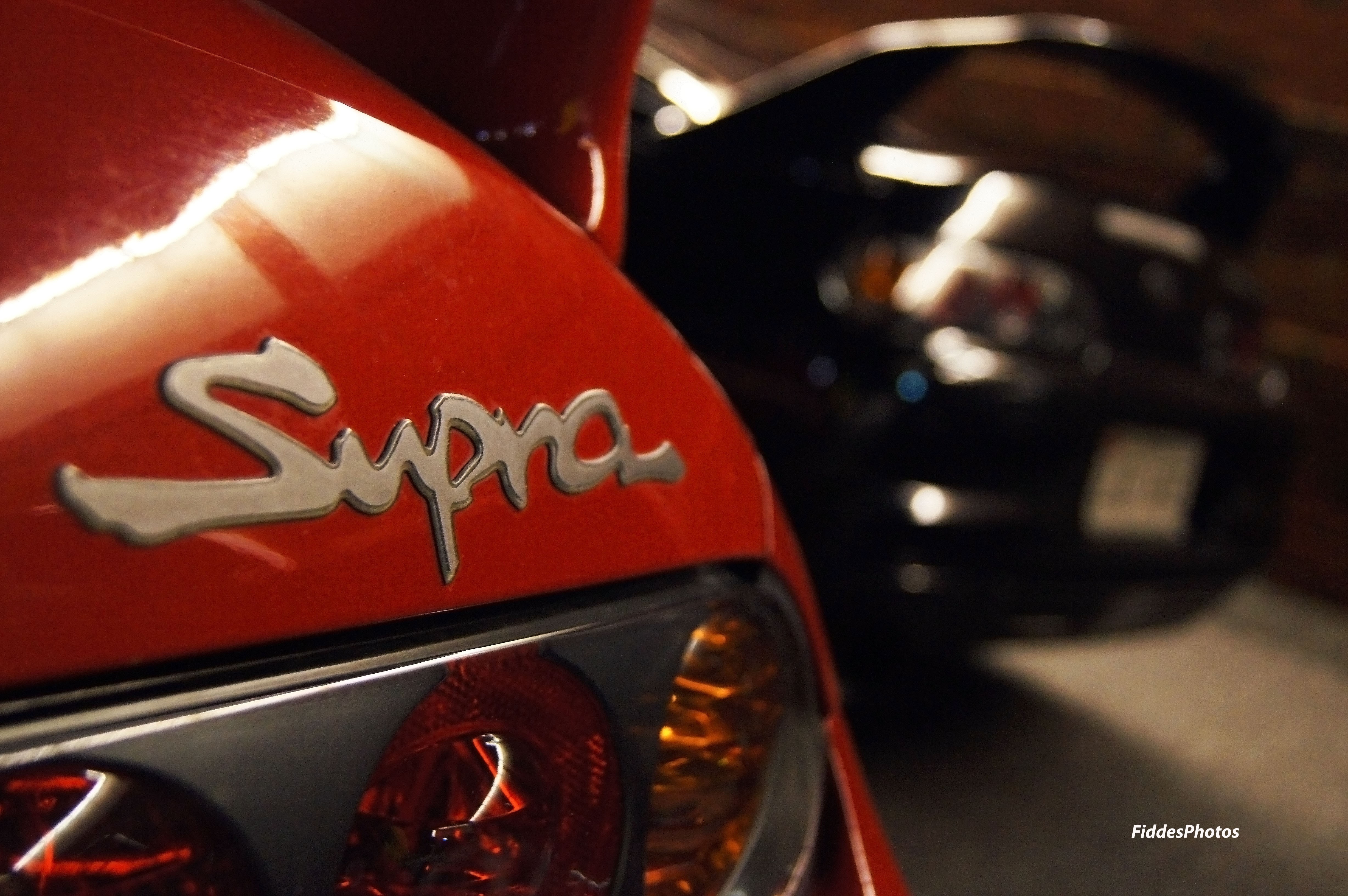 Red Toyota Supra emblem and black Toyota Supra HD Wallpaper