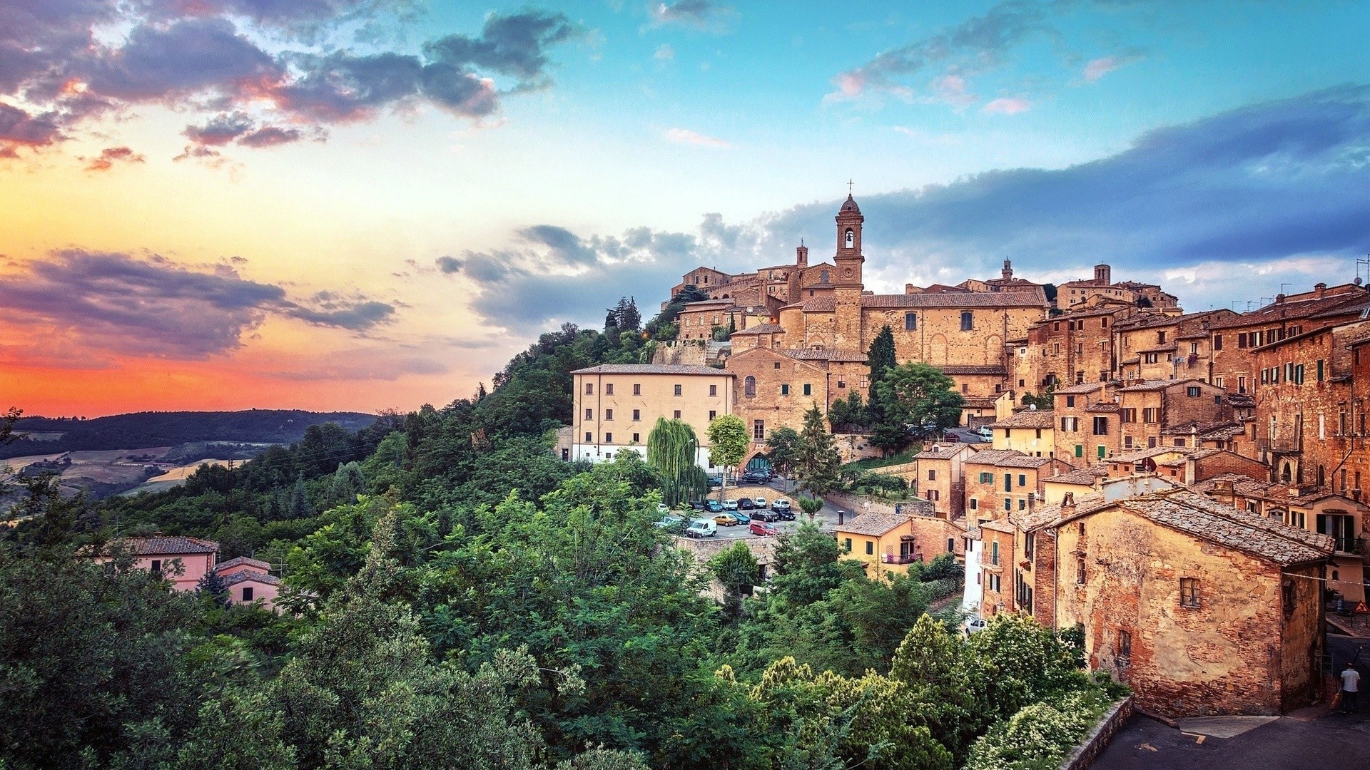 Tuscan town on a hill at sunset with forest HD Wallpaper
