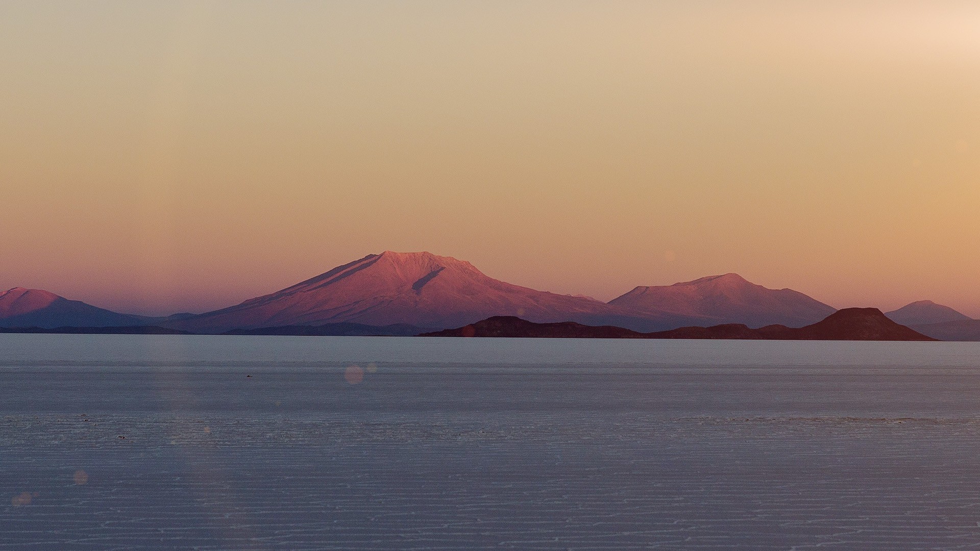 Mountains over salt flats at sunset HD Wallpaper