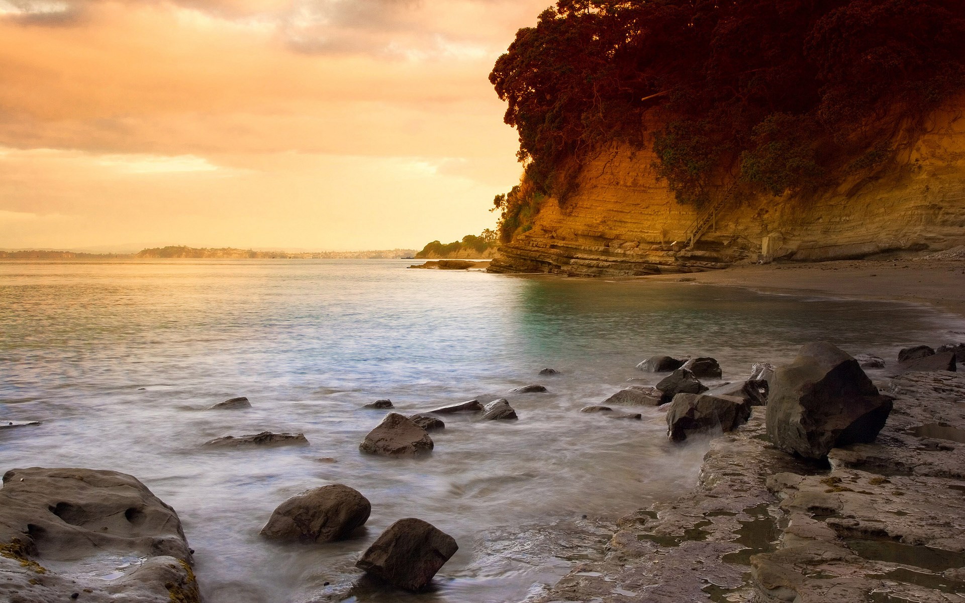 Ocean waves crashing on rocky shore at sunset HD Wallpaper