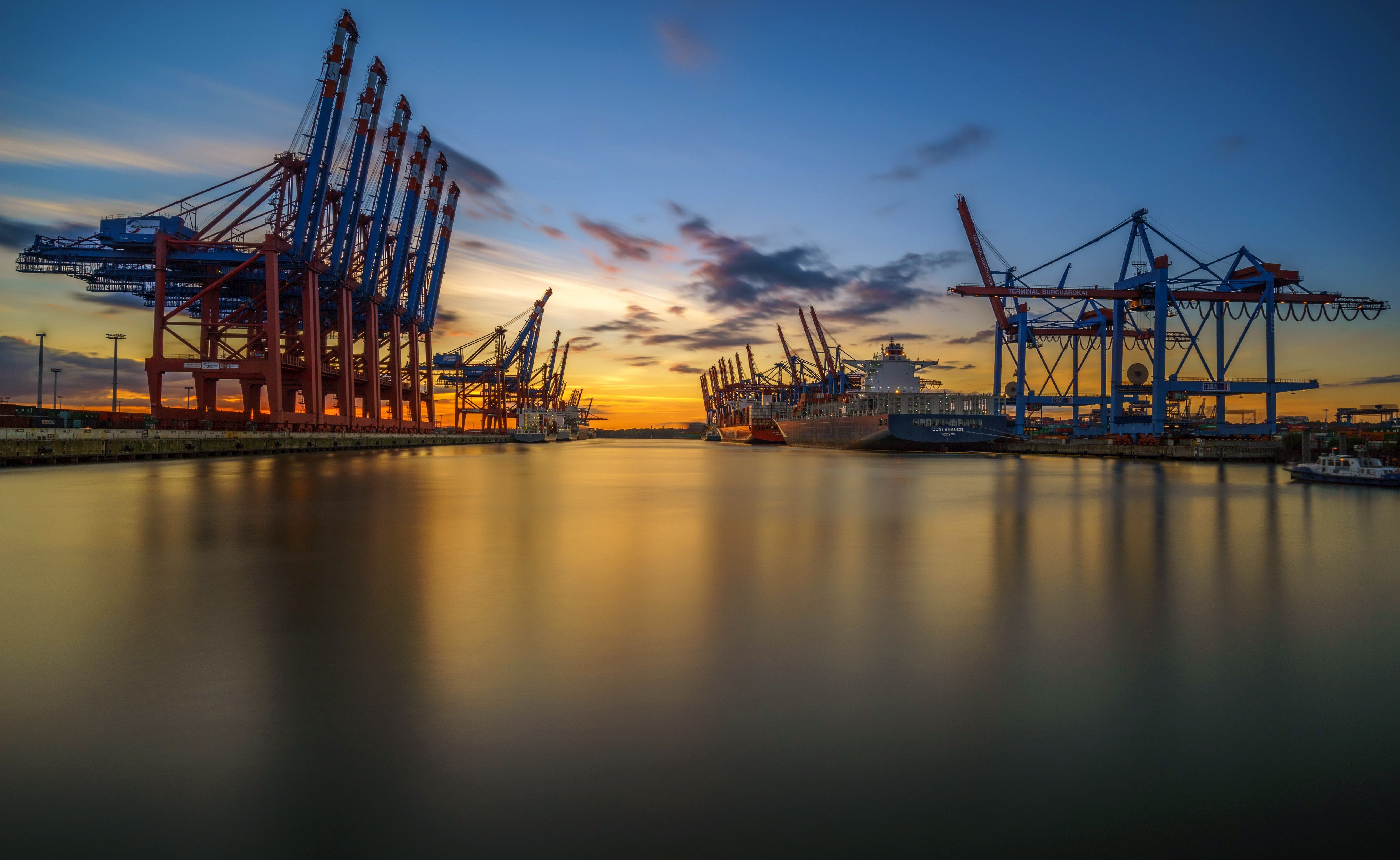 Hamburg harbor cranes and cargo ship at sunset HD Wallpaper