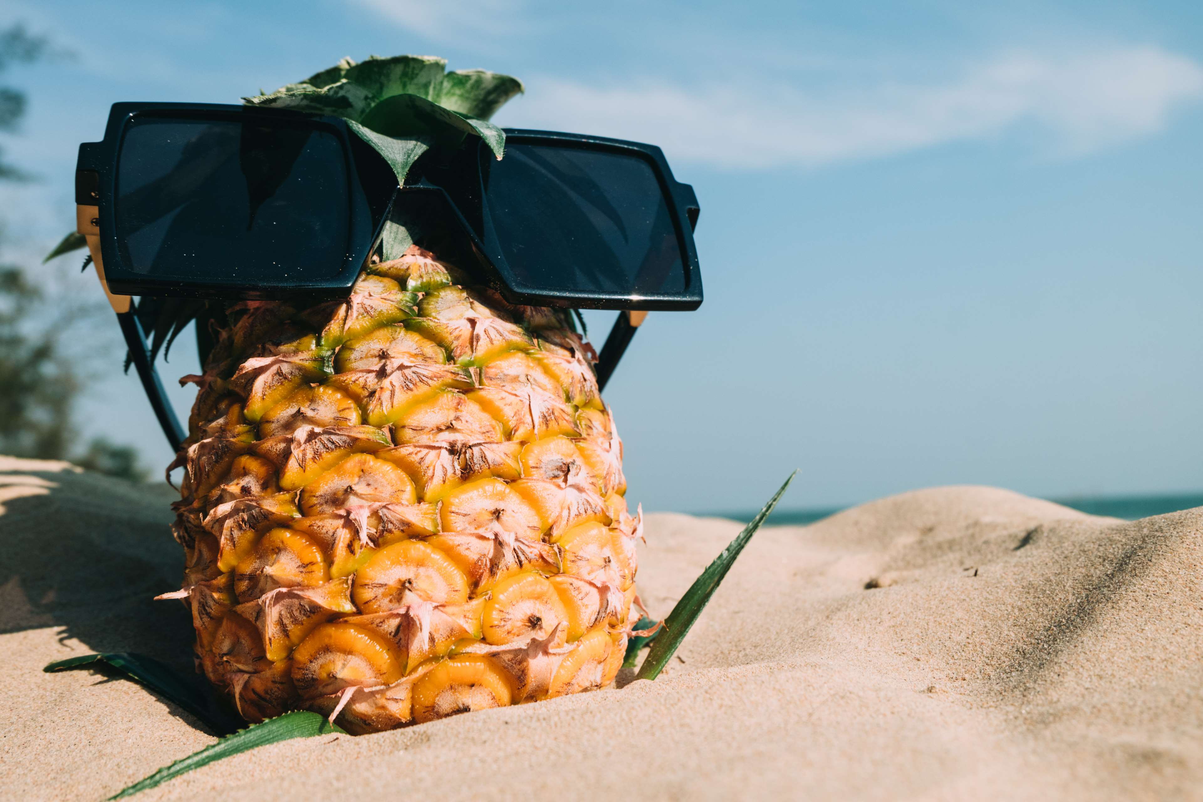 Pineapple with sunglasses on a sandy beach HD Wallpaper