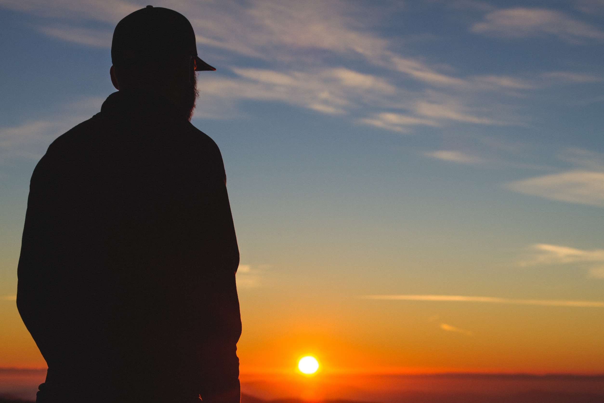Man in silhouette watching the sunset HD Wallpaper
