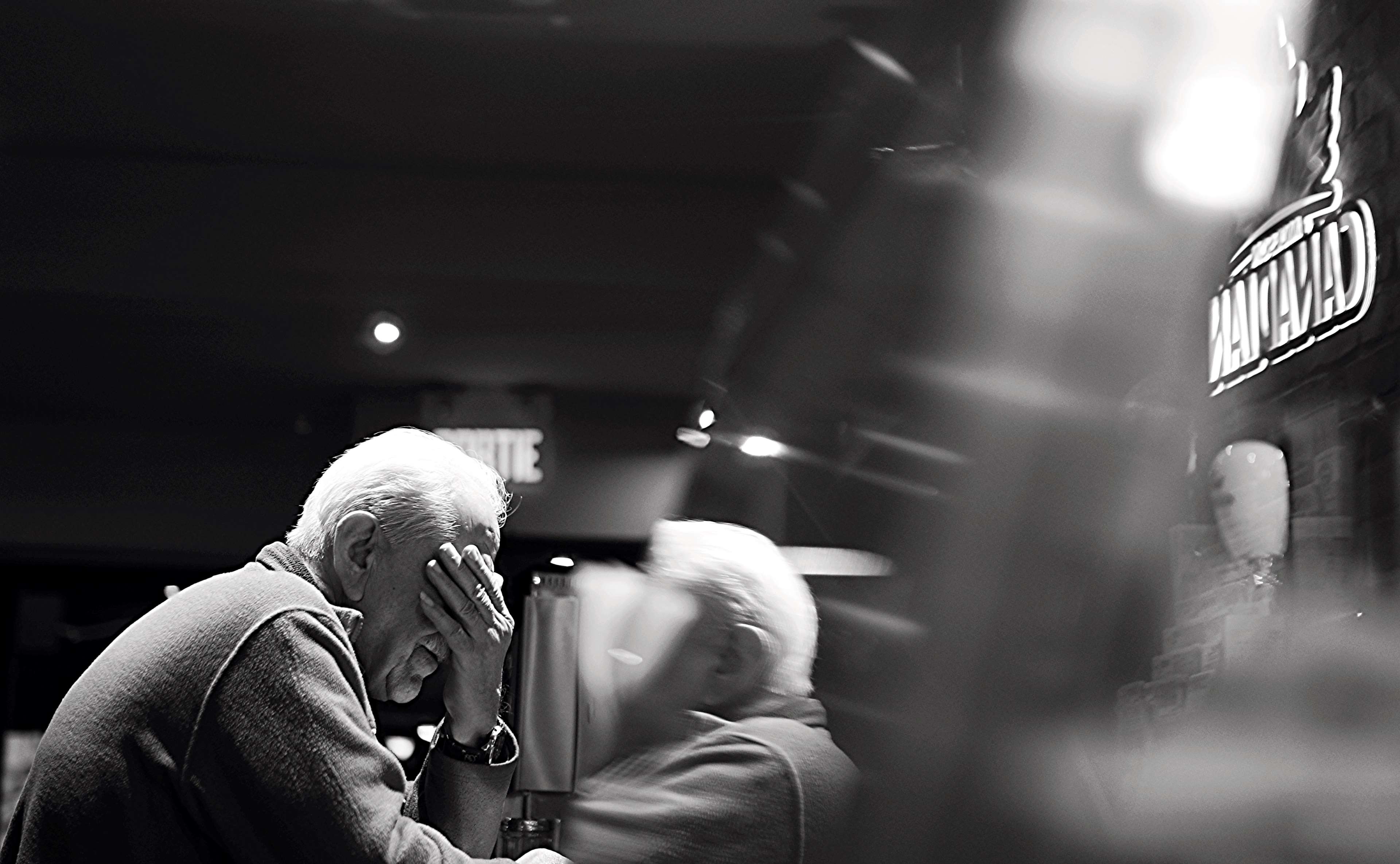 Elderly man with hand over face in black and white HD Wallpaper