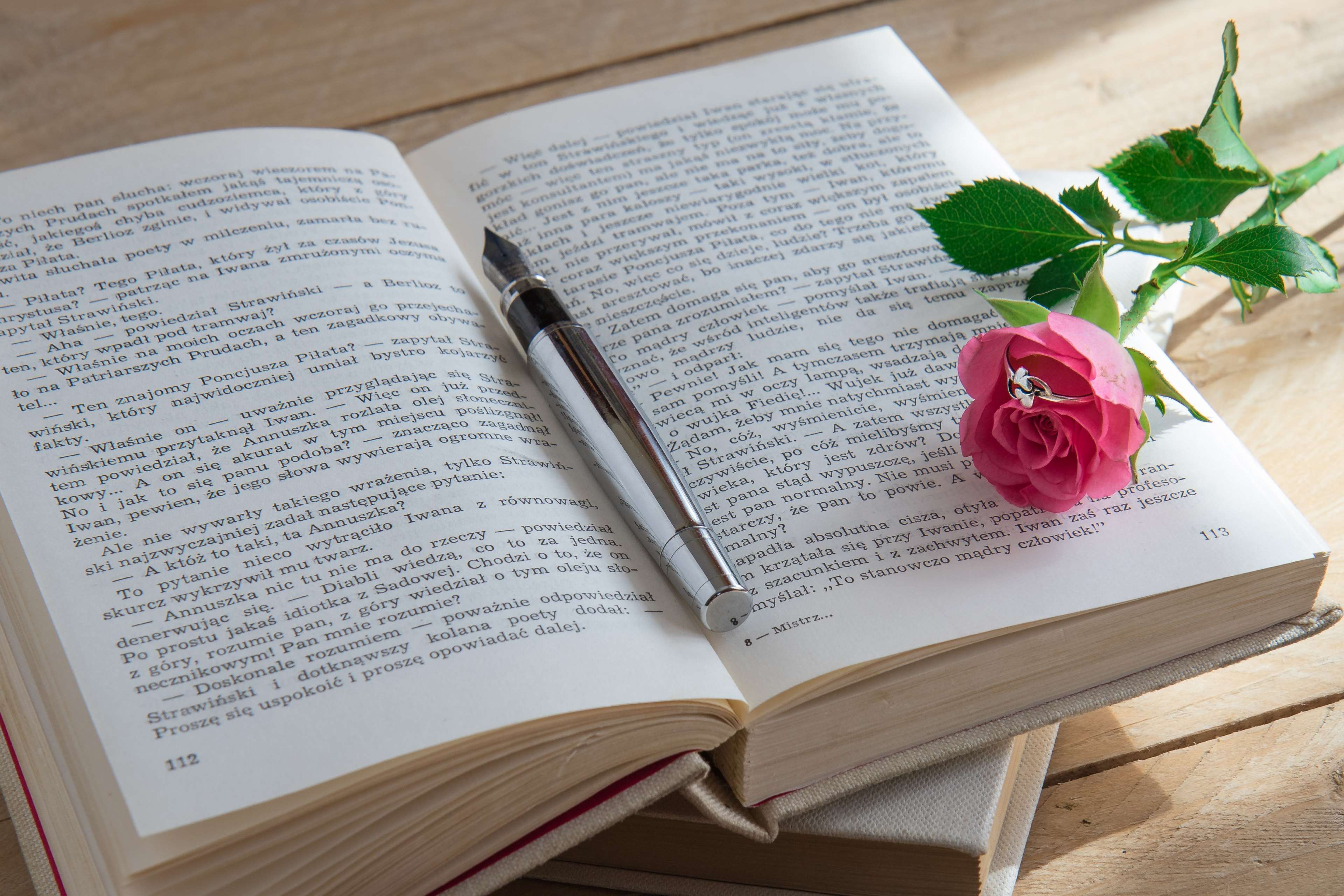 Open book with pen and rose with ring HD Wallpaper
