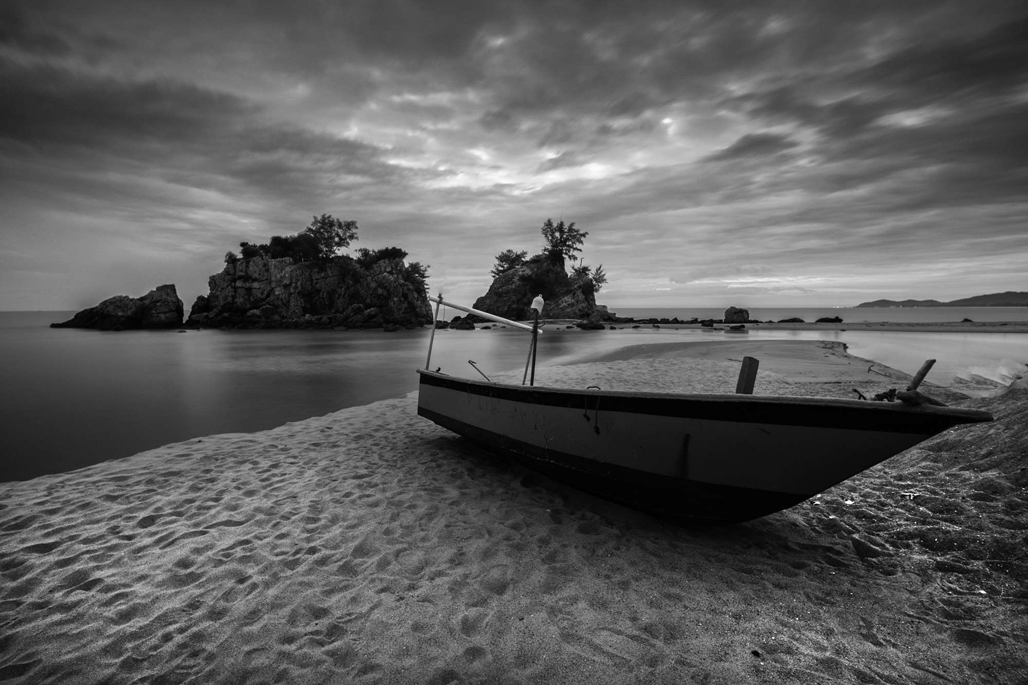Boat on a sandy beach with islands in the background HD Wallpaper