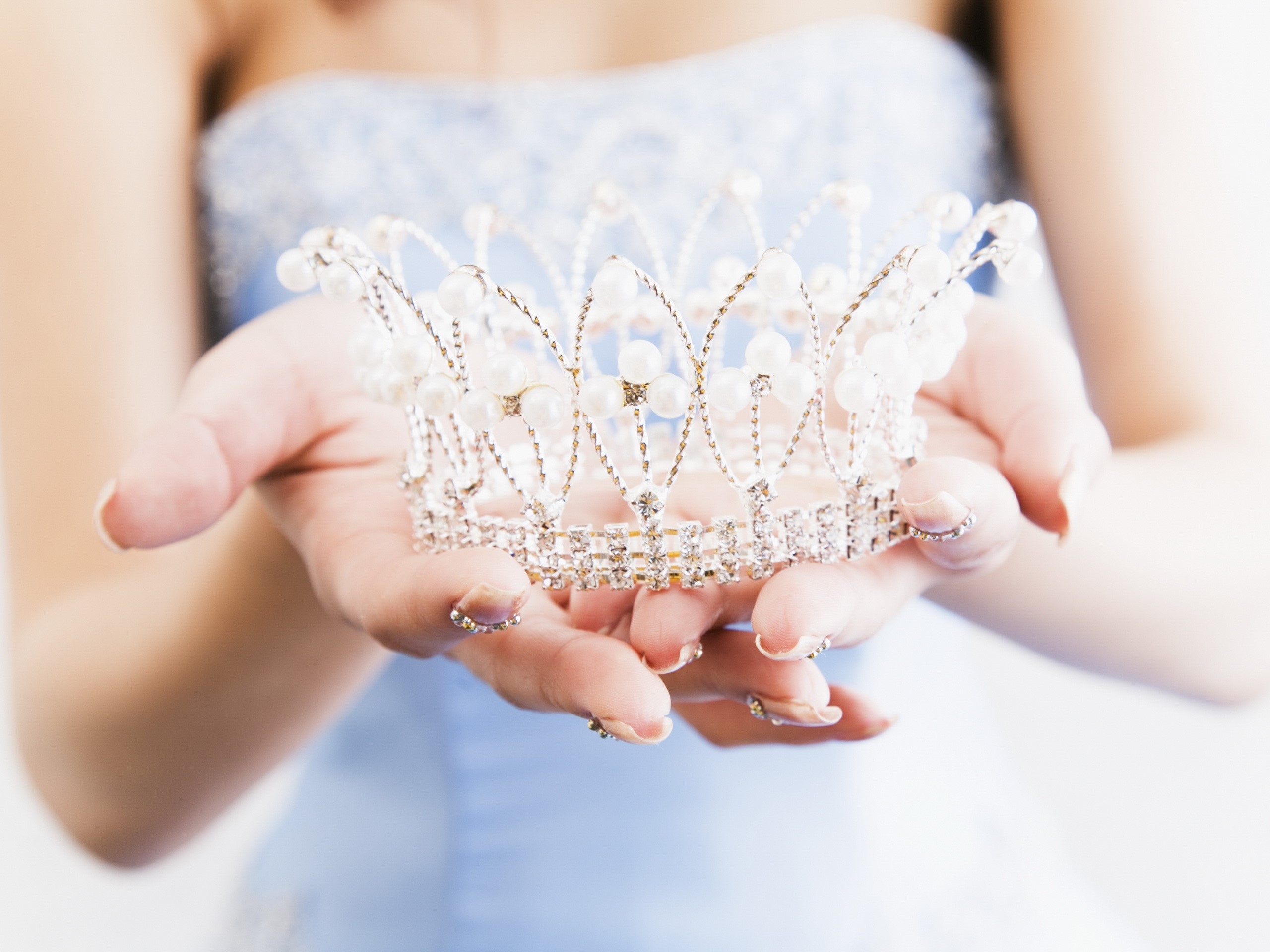 Hands holding a pearl and diamond crown HD Wallpaper
