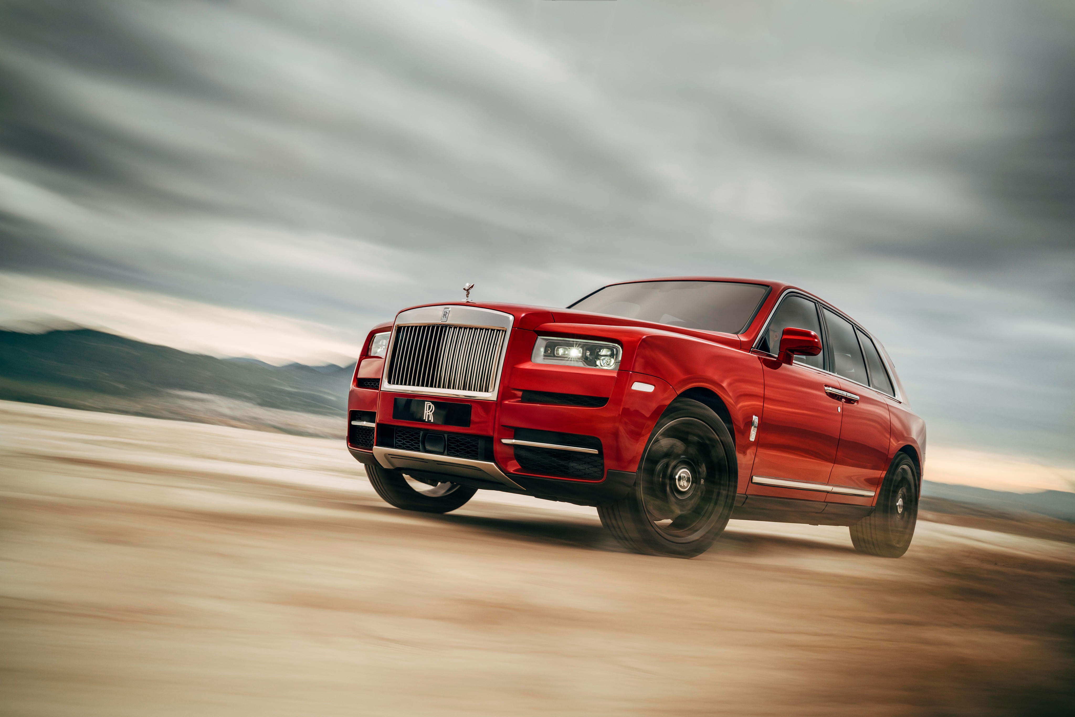 Red Rolls-Royce Cullinan driving on a dirt road HD Wallpaper