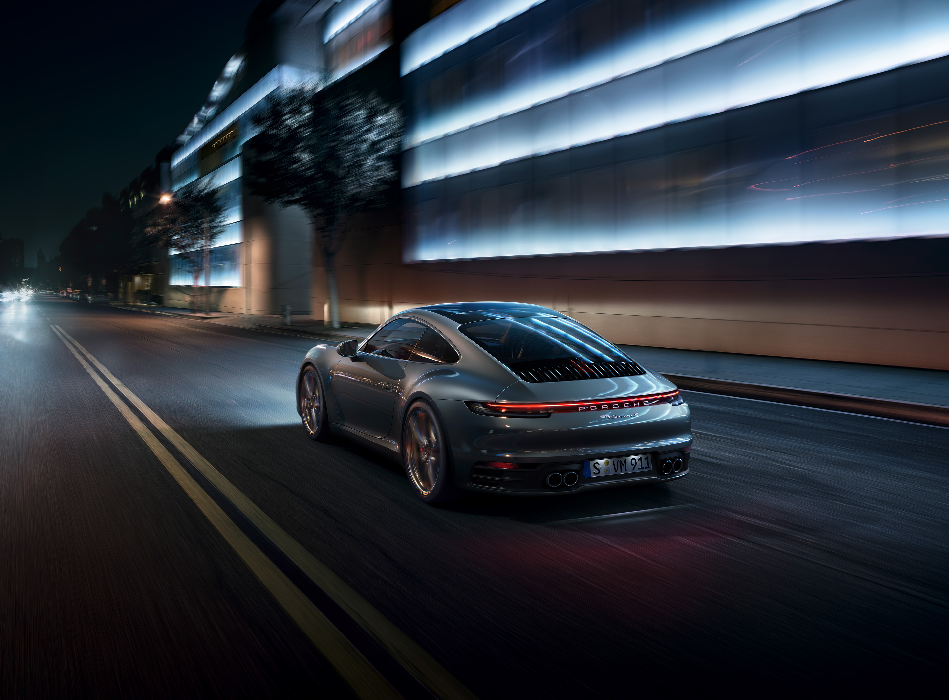 Porsche 911 driving on a city street at night HD Wallpaper