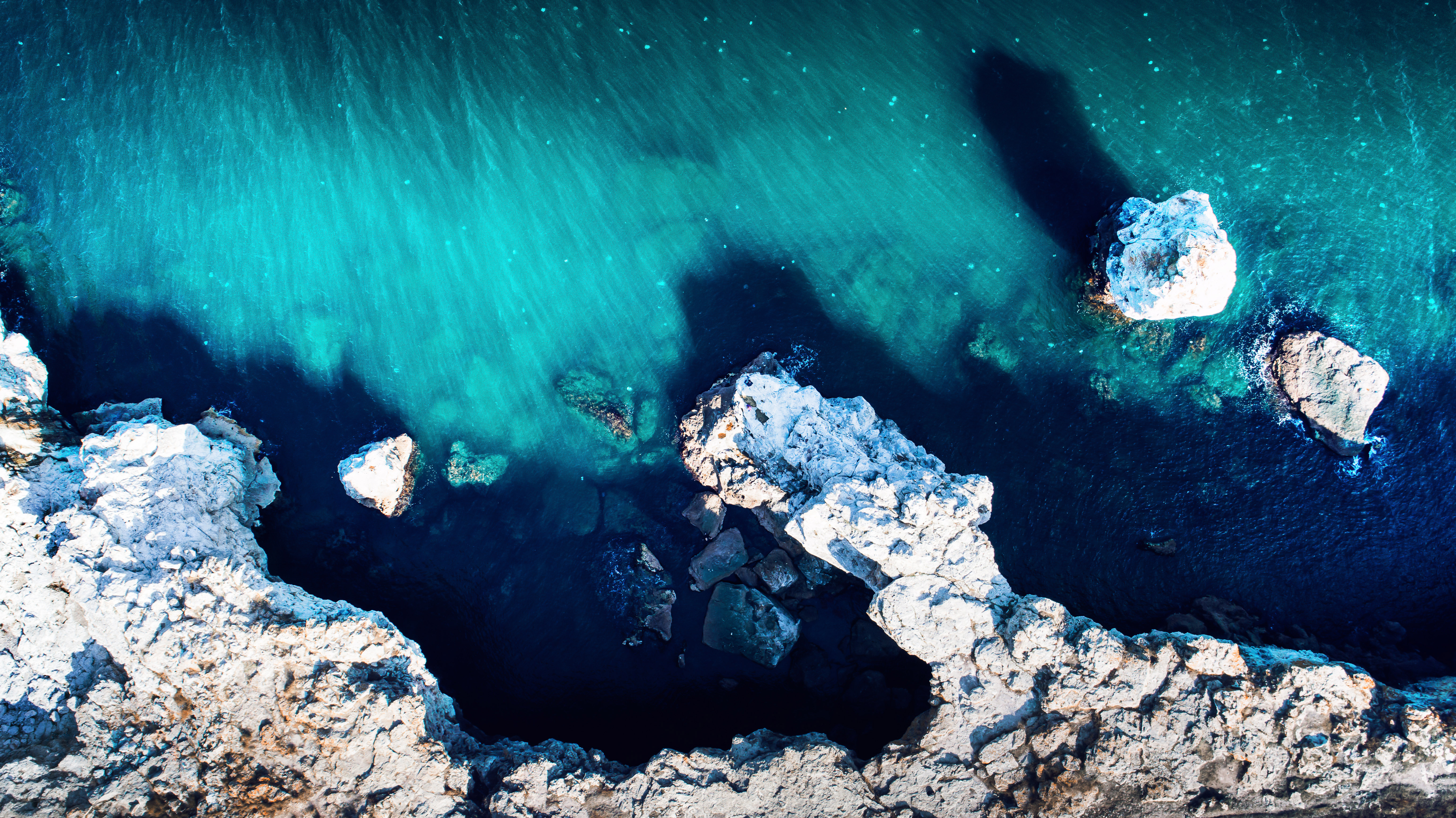 Aerial view of rocky coastline and turquoise ocean HD Wallpaper