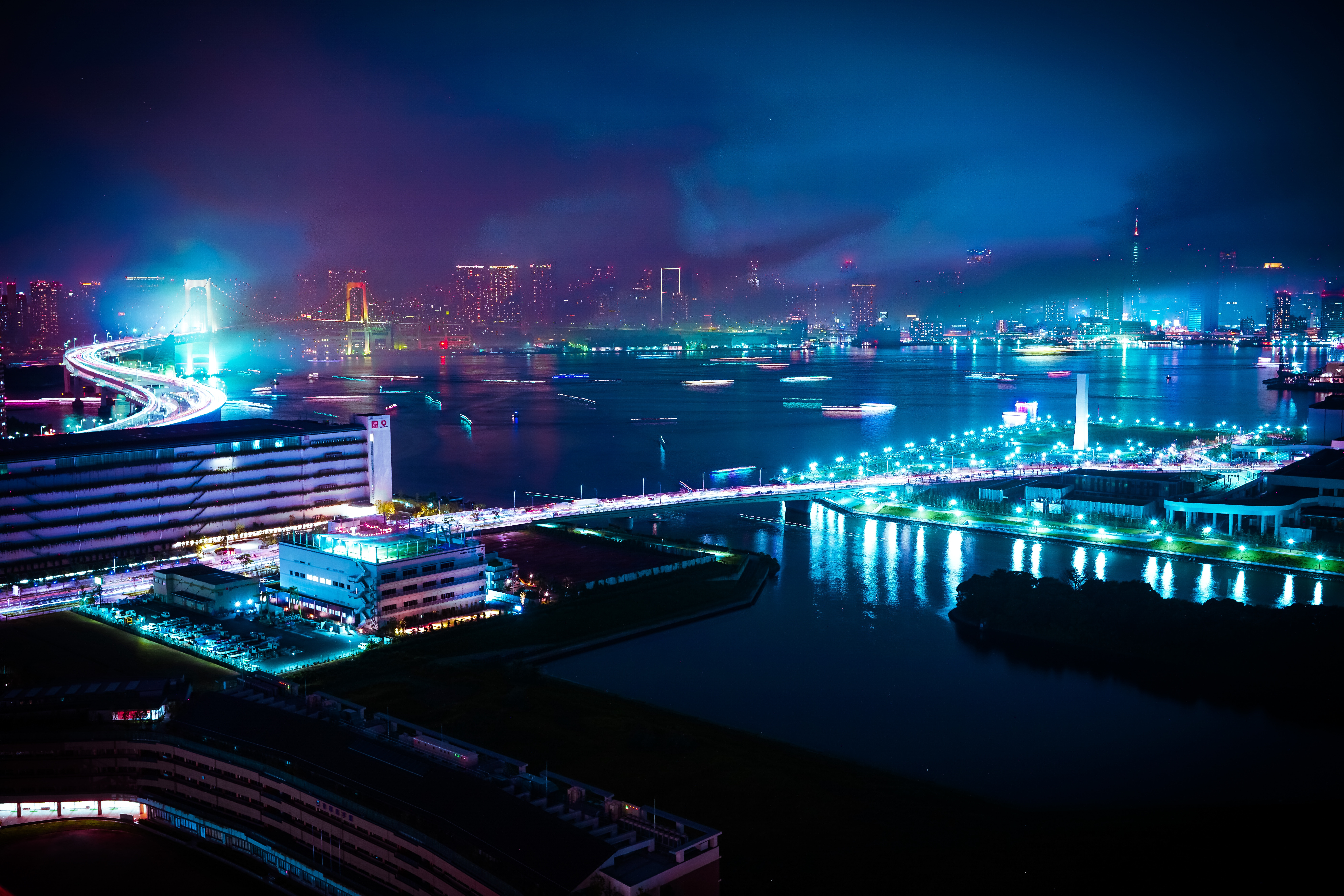 Nighttime cityscape with illuminated bridges and water traffic HD Wallpaper