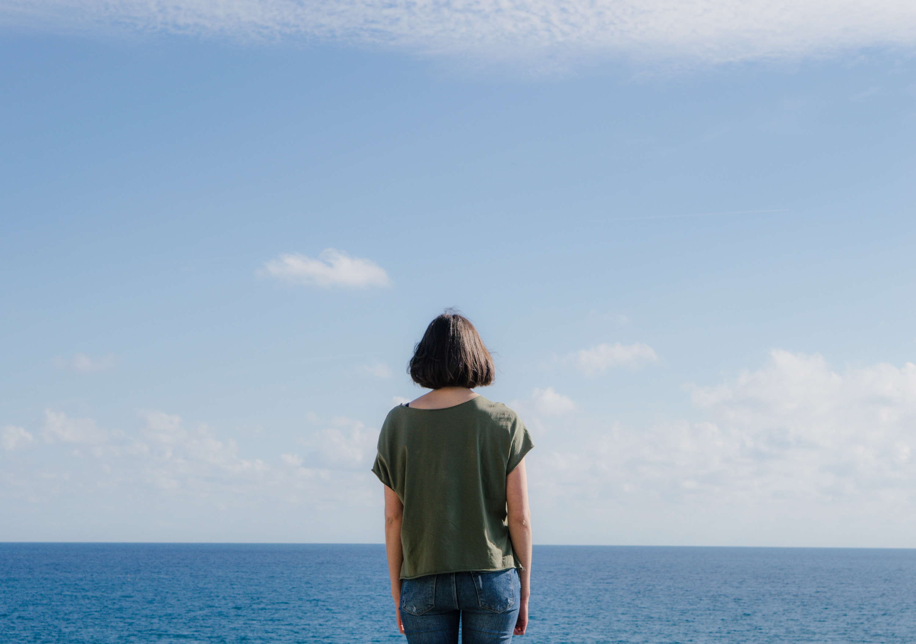 Woman in green shirt looking at the ocean HD Wallpaper