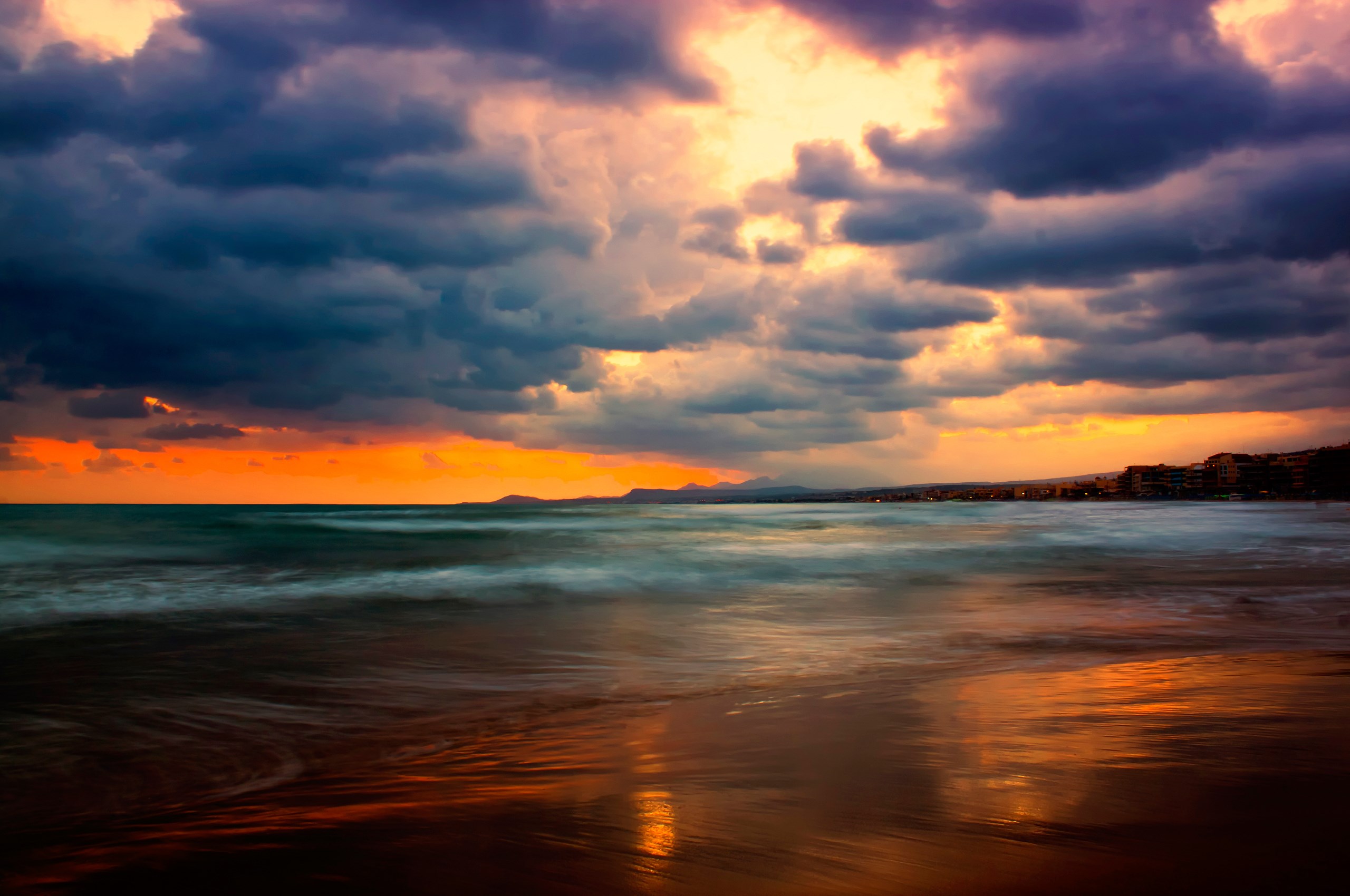 Dramatic sunset over a beach with ocean waves HD Wallpaper