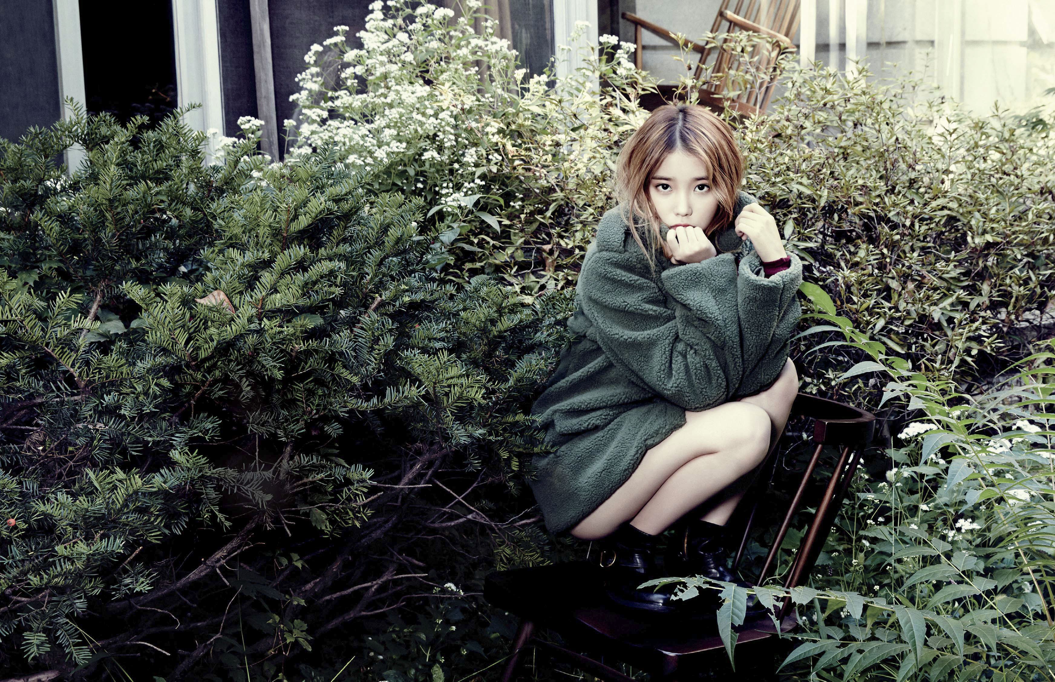 IU sitting in a garden HD Wallpaper