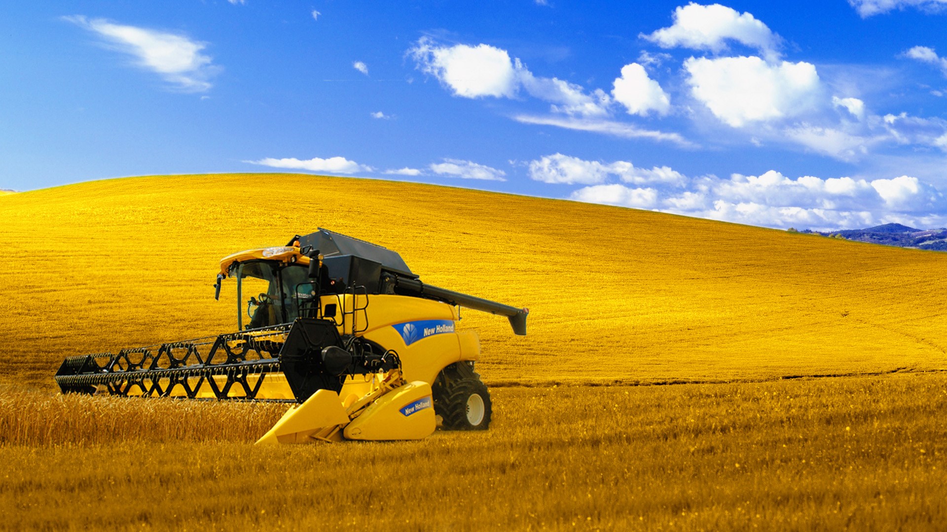 New Holland combine harvester in a golden field HD Wallpaper