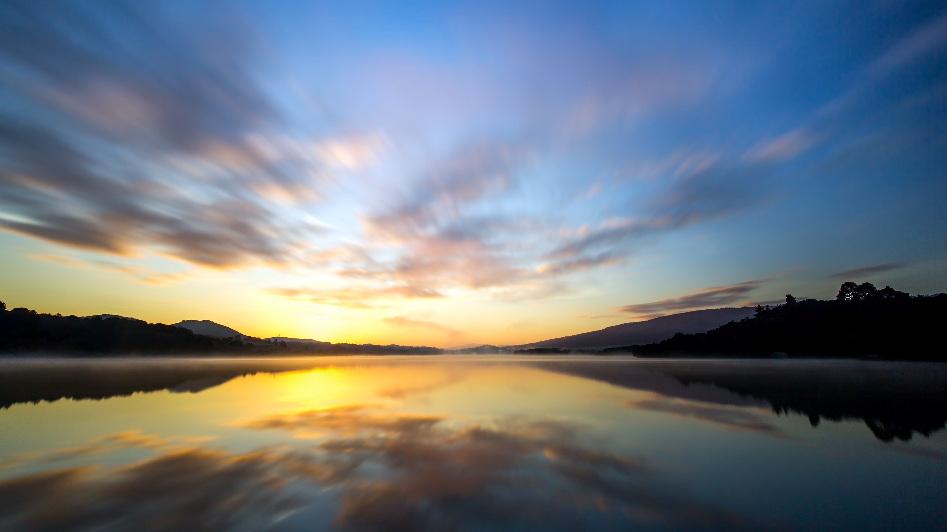 4K sunrise over a misty lake with clouds HD Wallpaper