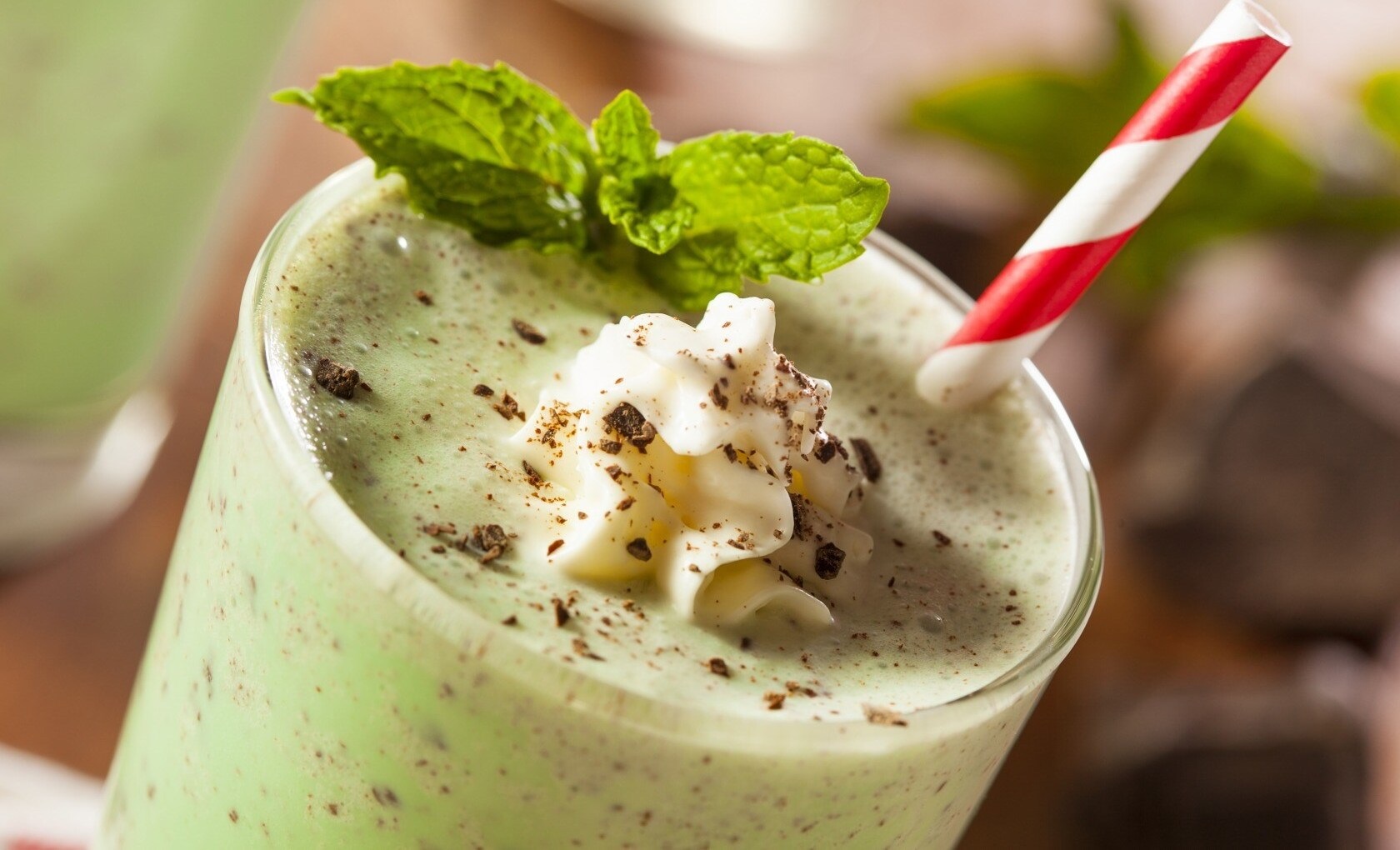 Mint chocolate chip milkshake with whipped cream and mint leaves HD Wallpaper