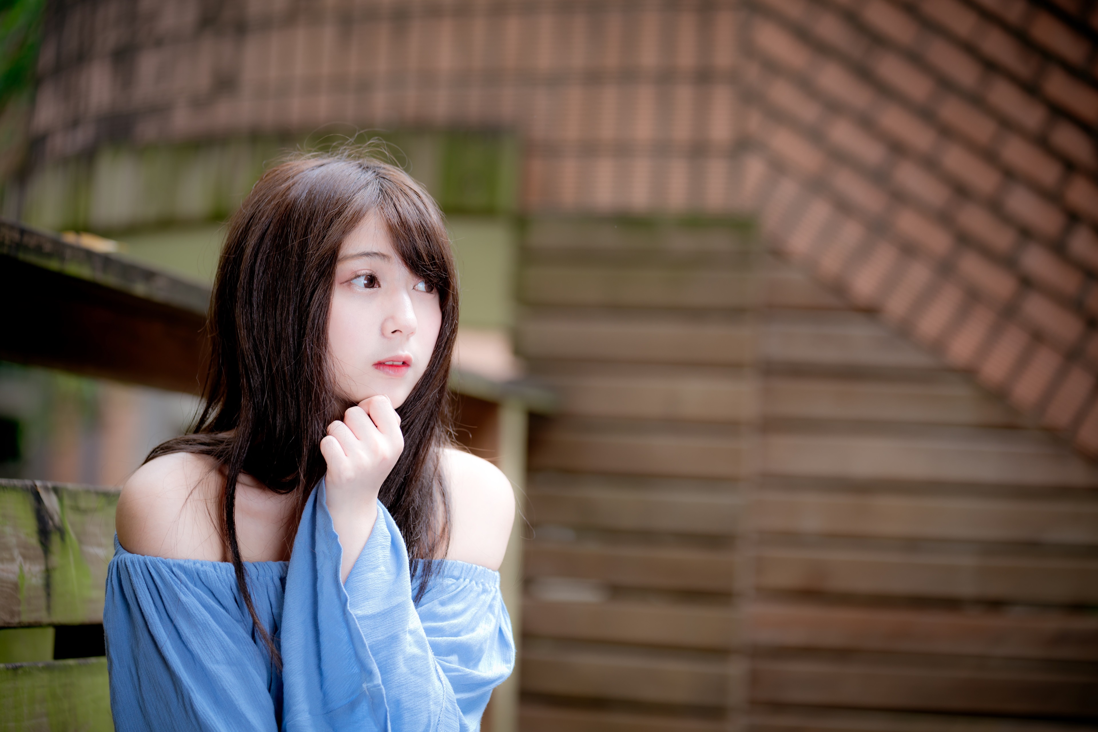 Asian girl in blue off-shoulder top sitting outdoors HD Wallpaper
