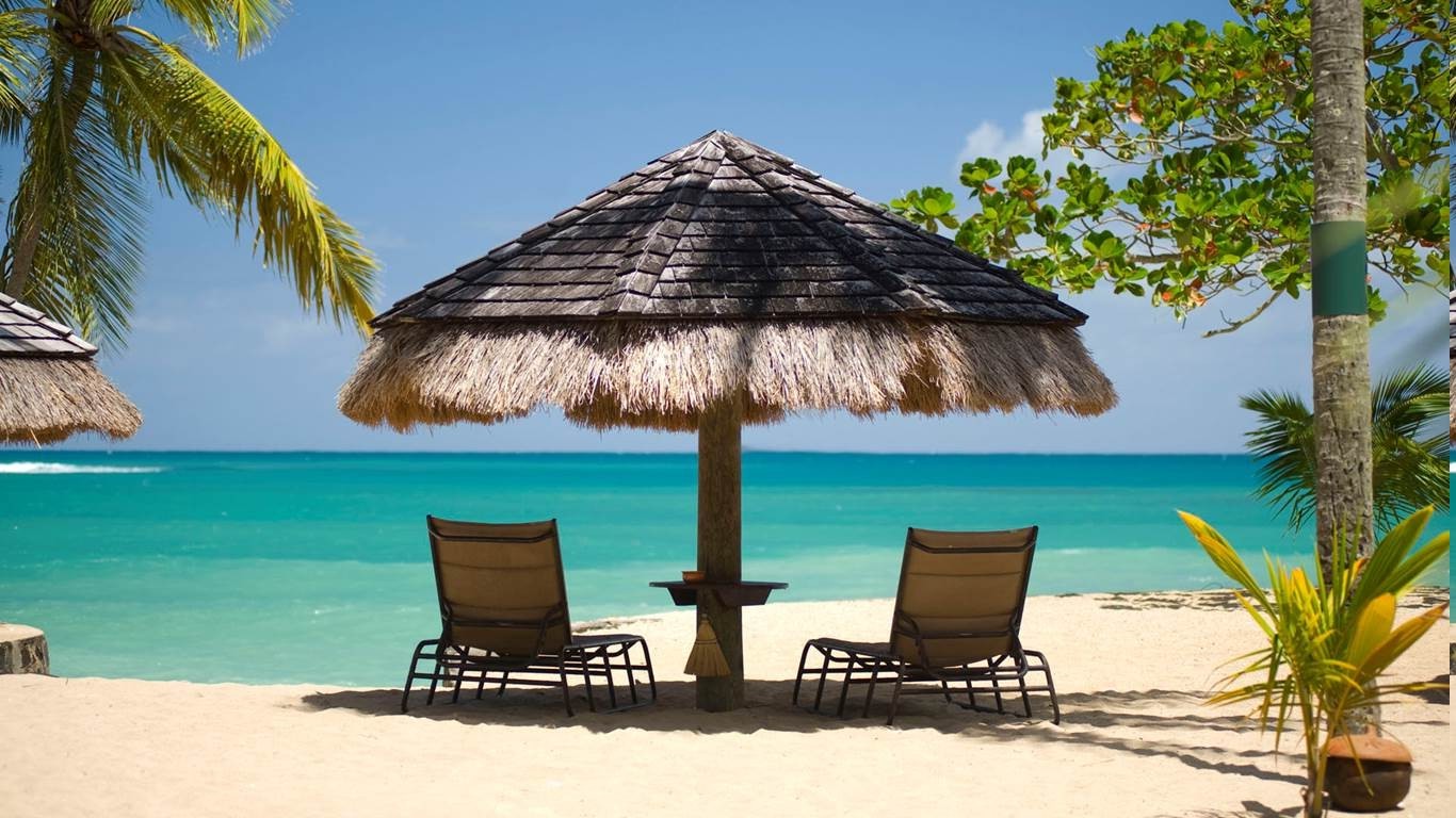 Tropical beach with lounge chairs and umbrellas HD Wallpaper