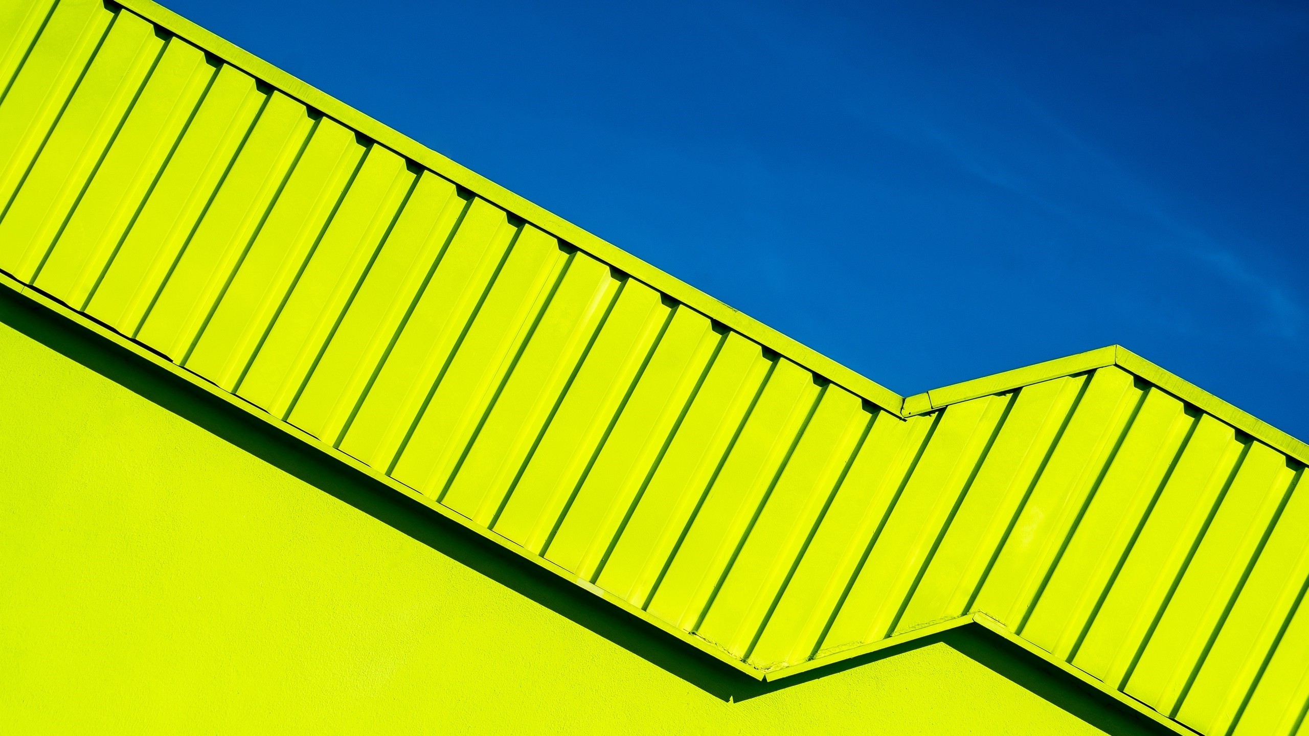Abstract yellow rooftop against a clear blue sky HD Wallpaper