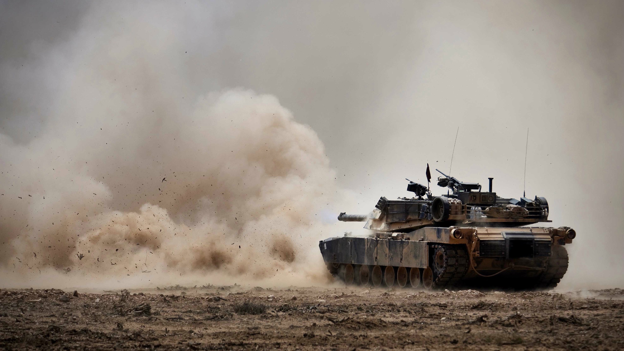 M1 Abrams tank firing in dusty environment HD Wallpaper
