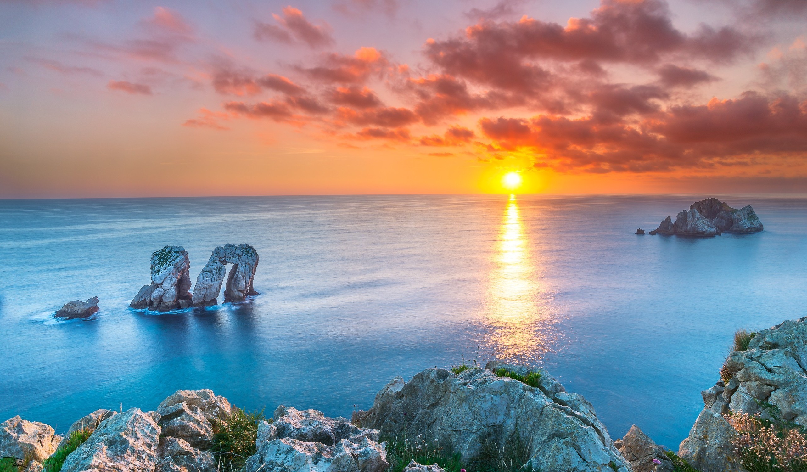 Sunset over the ocean with rock formations in Spain HD Wallpaper