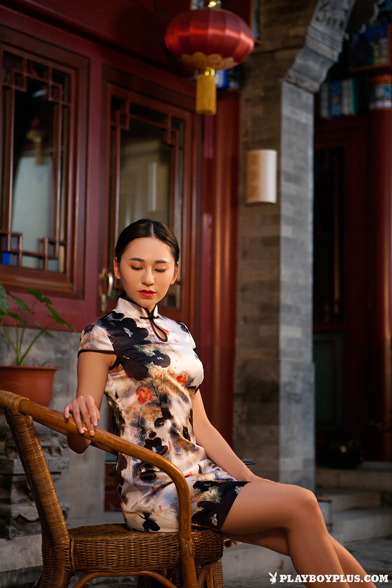 Woman in a floral cheongsam sitting on a chair HD Wallpaper
