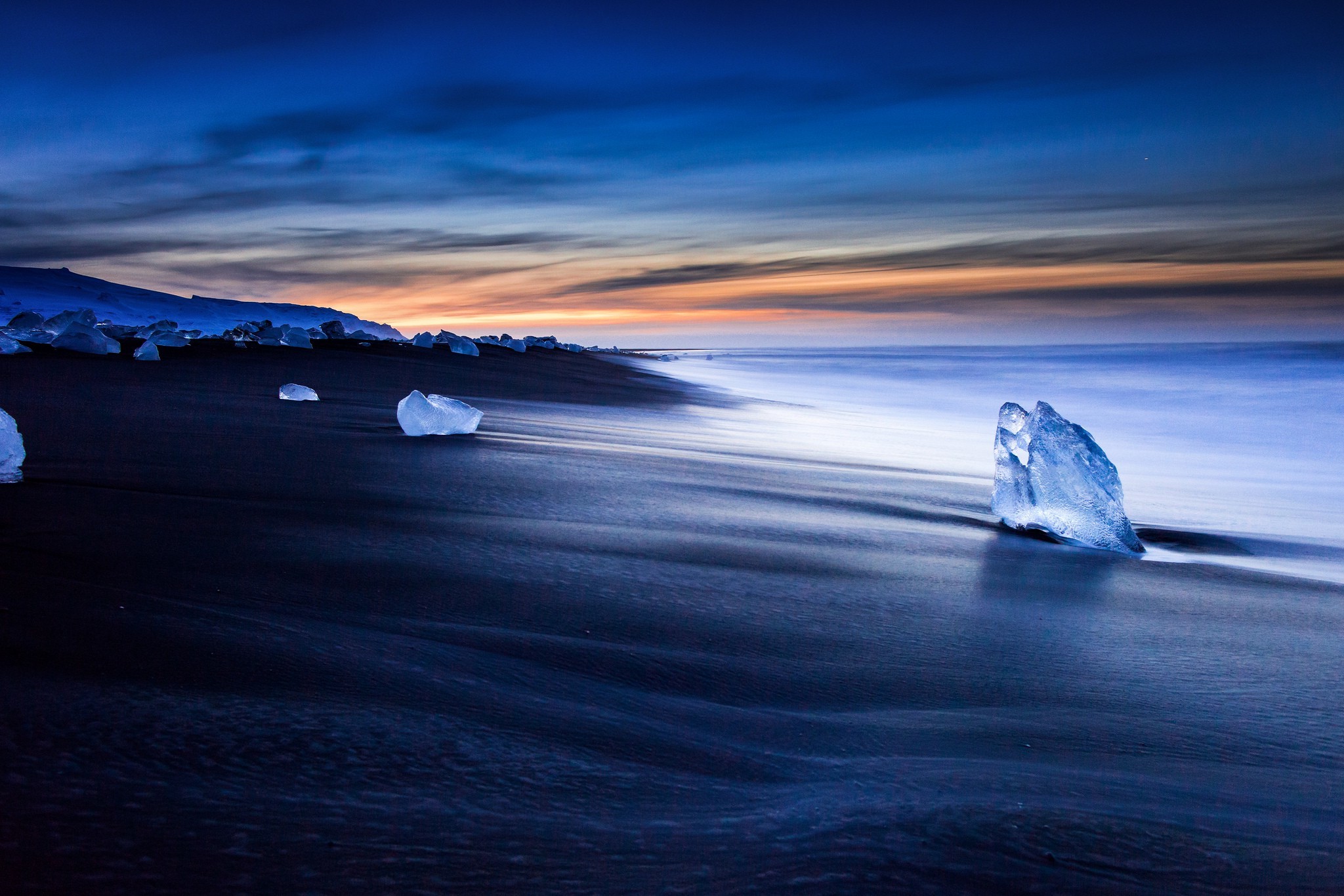 Icebergs on a black sand beach at sunset HD Wallpaper