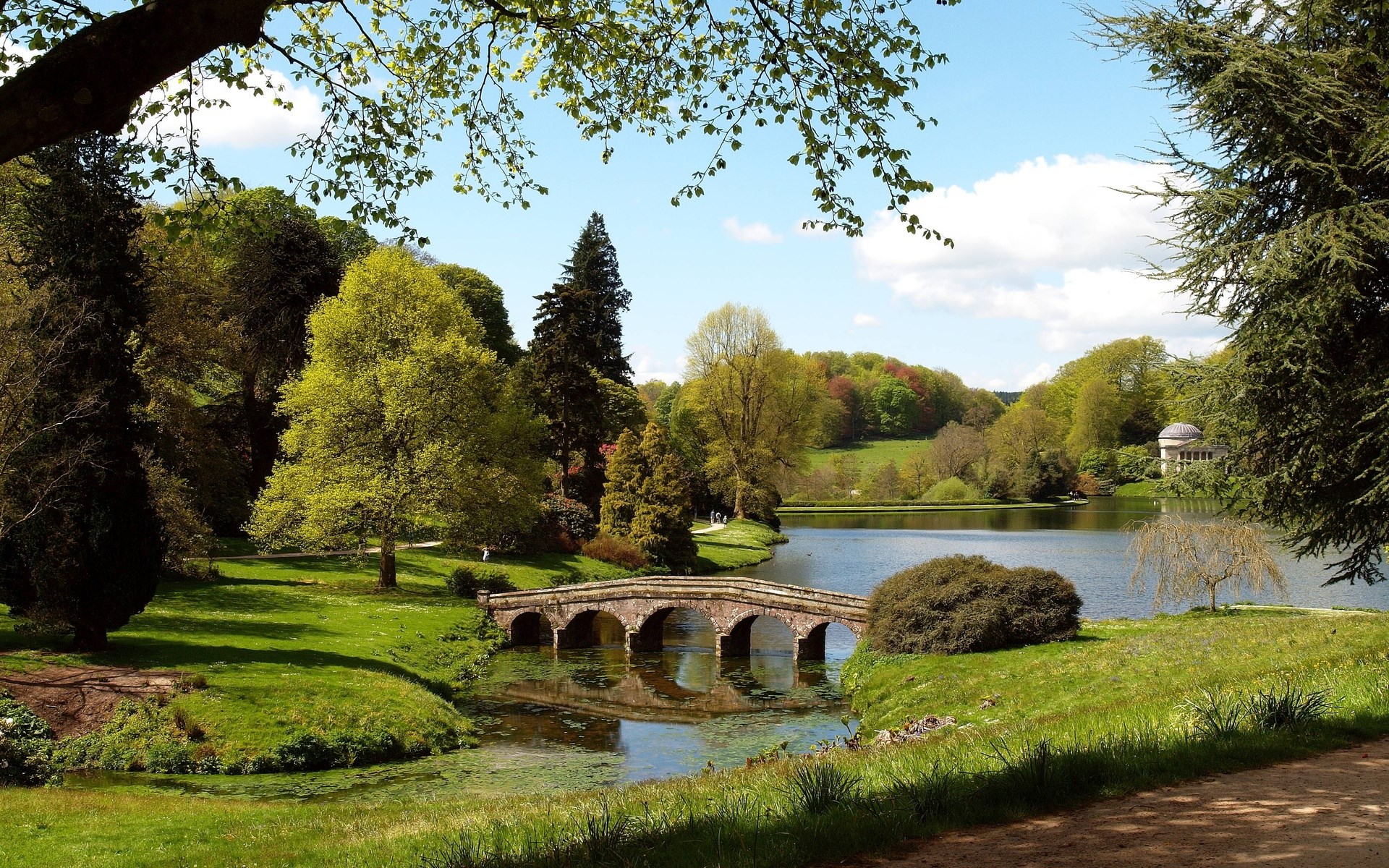 Stone bridge over a lake in a park HD Wallpaper
