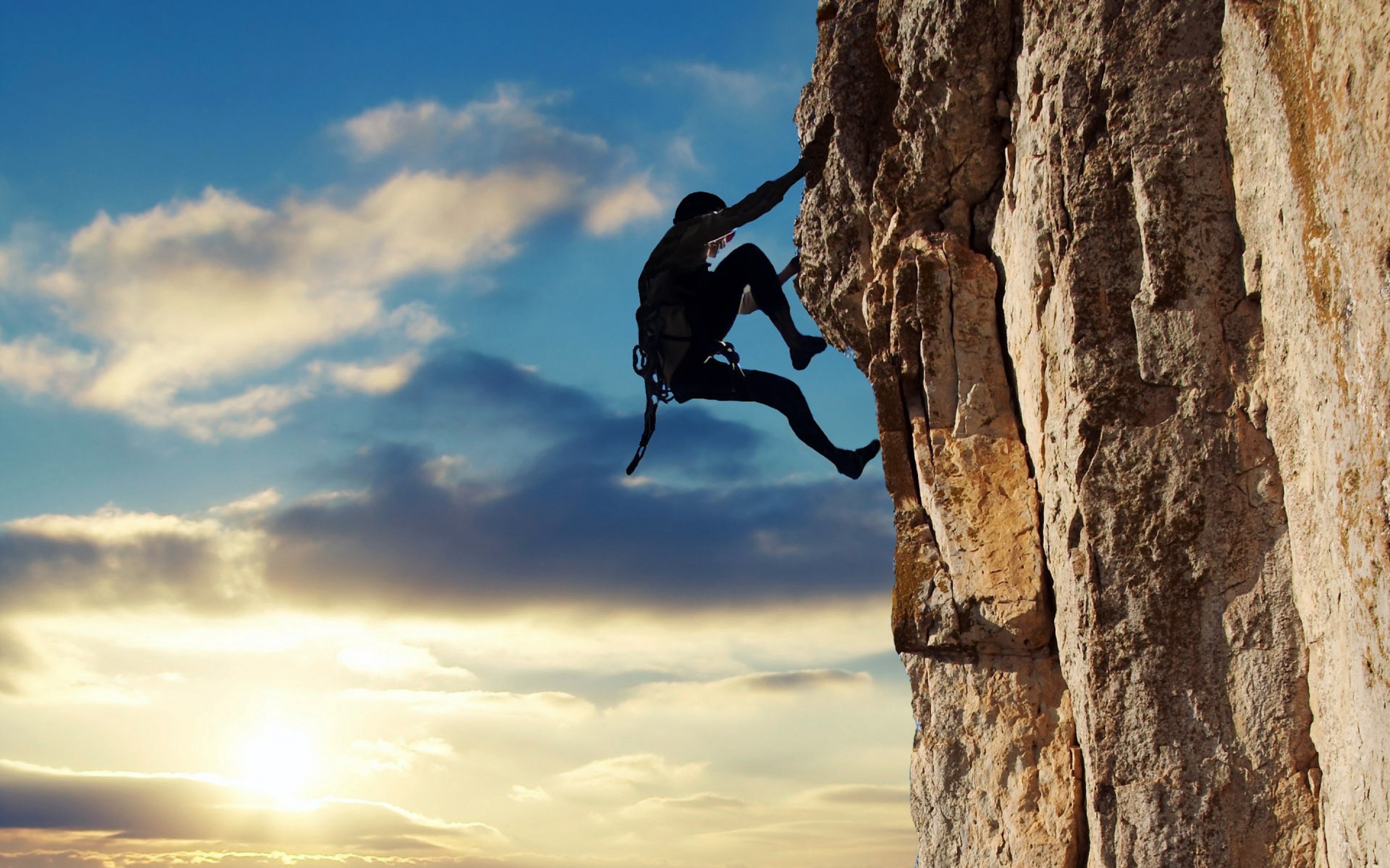 Silhouette of a rock climber on a cliff face HD Wallpaper