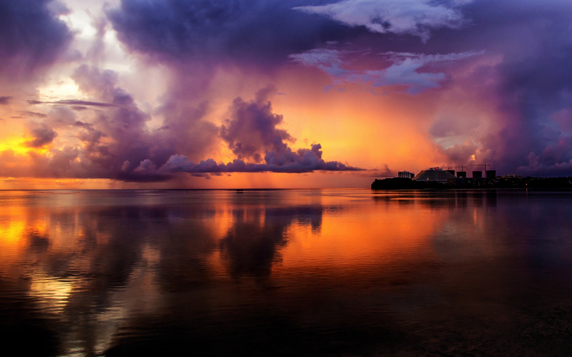 Dramatic sunset over the ocean with city skyline HD Wallpaper