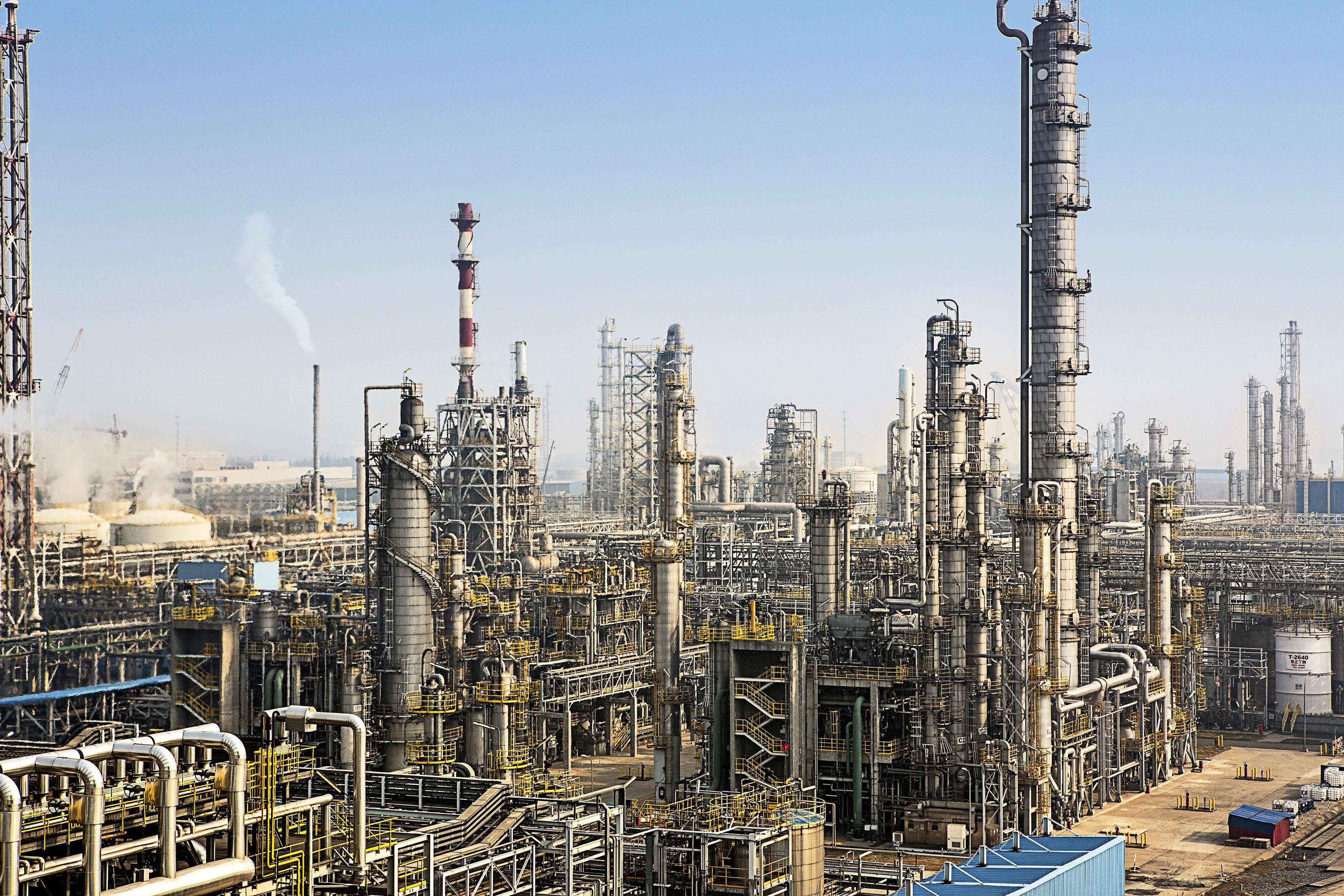 Industrial oil refinery with tall towers and pipes HD Wallpaper